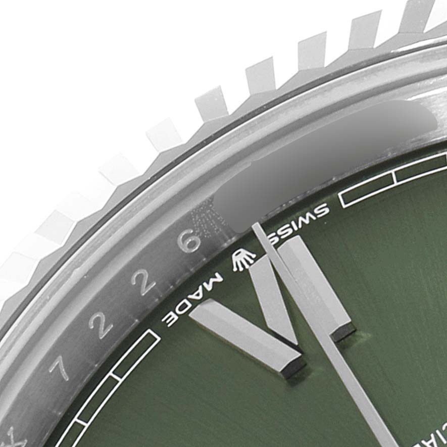 This close-up image of a Rolex President 228239 Men's White Gold Green Dial 228239 Men's White Gold Green Dial model watch shows part of the bezel, dial, and hands at an angle.