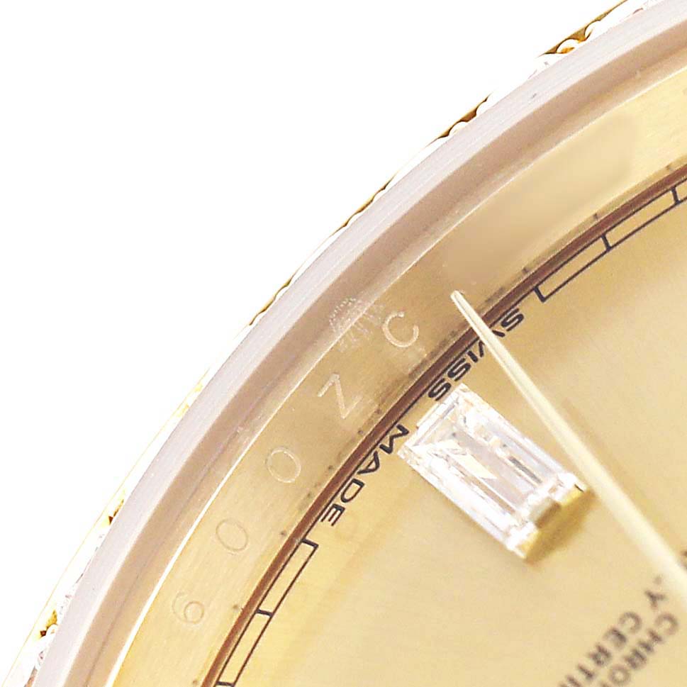 The image shows a close-up of the dial edge and part of the hand of a Rolex President 228348 Men's Yellow Gold Champagne Dial watch, highlighting the gem and “SWISS MADE” text.