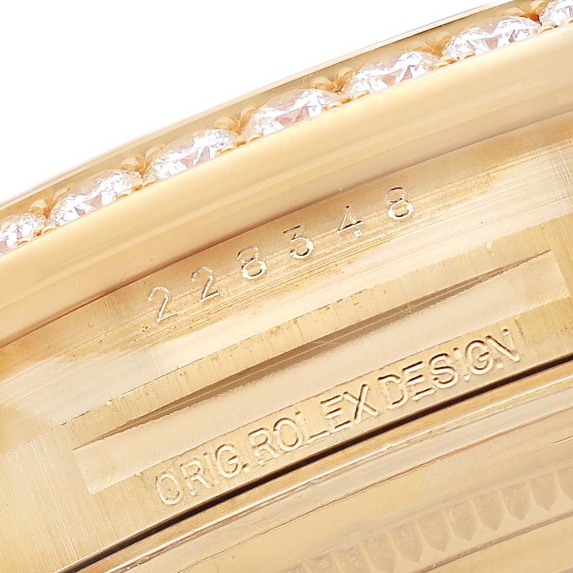 The image shows the side of a Rolex President 228348 Men's Yellow Gold Champagne Dial model, featuring the engraved serial number and part of a diamond-studded bezel.