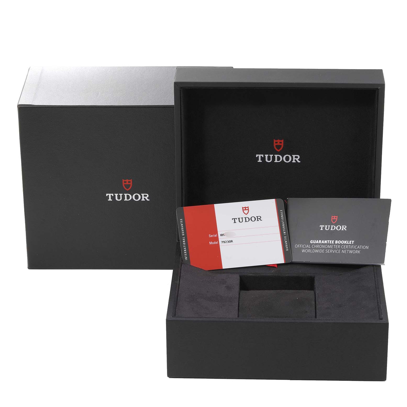 The image shows the open box for the Tudor Heritage Black Bay 79230R Men
s Stainless Steel Black Dial 79230R Men
s Stainless Steel Black Dial watch, including the warranty card and guarantee booklet.