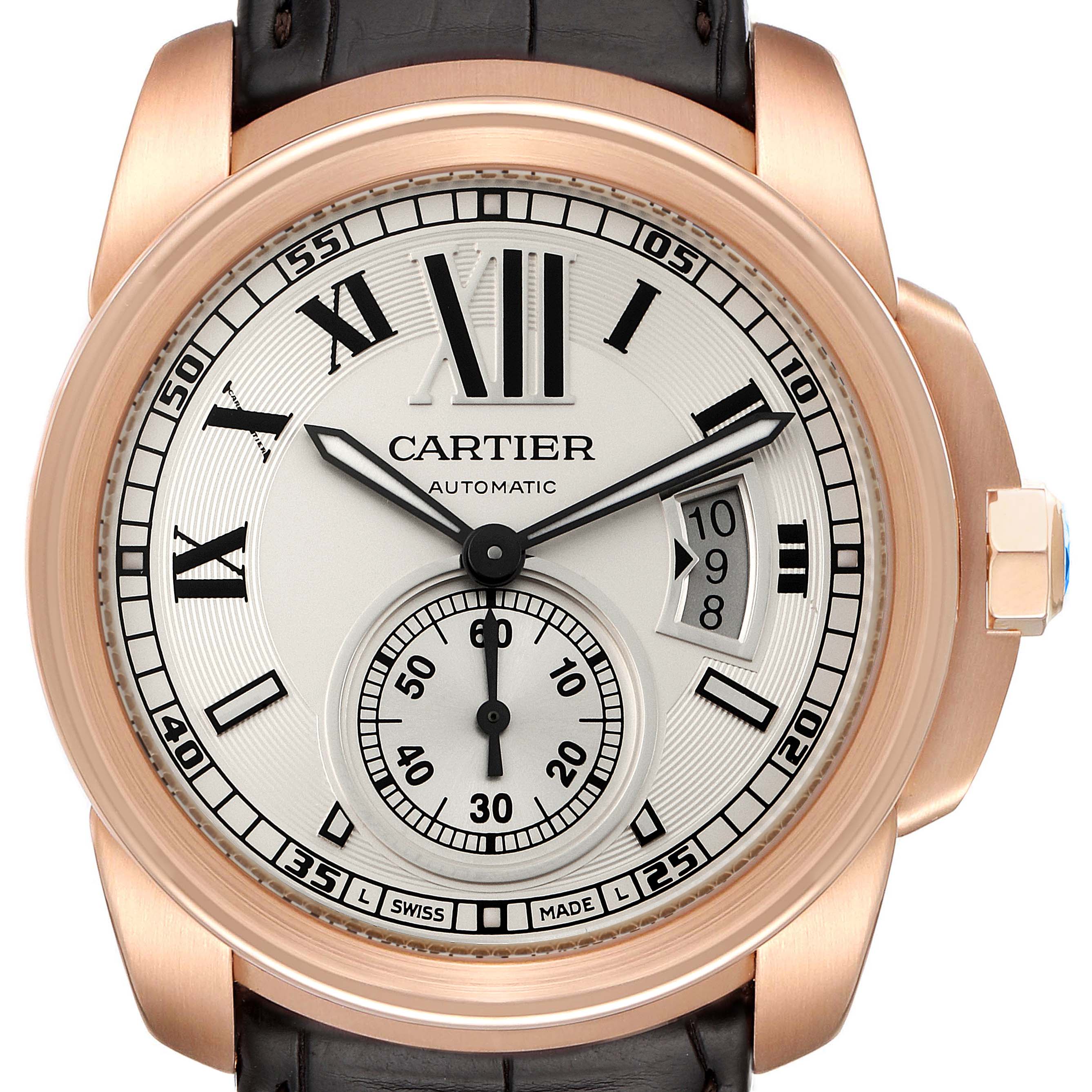 The image shows a front view of the Calibre de Cartier watch by Cartier, highlighting the dial, hour markers, hands, and date window.