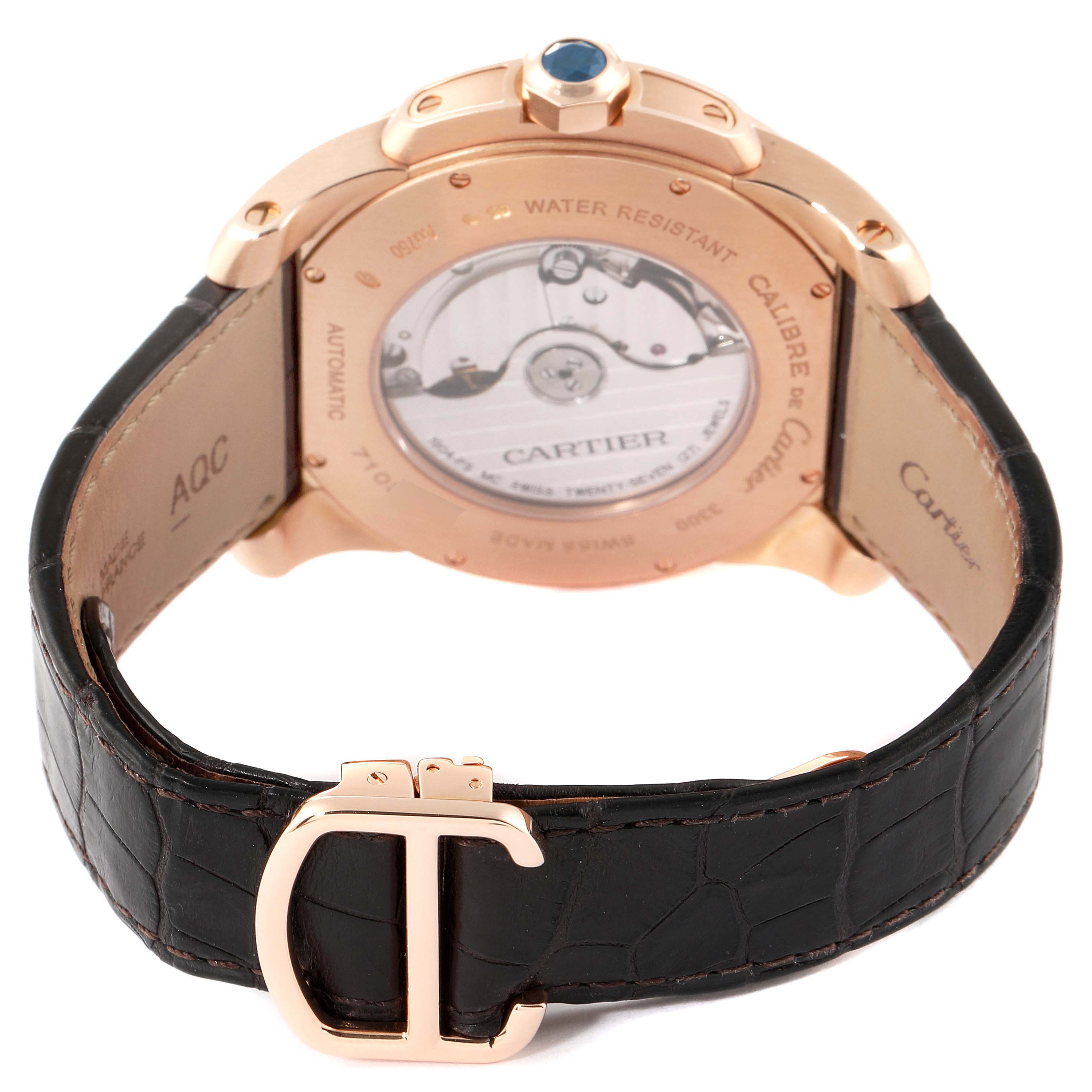 The image displays the back view of a Calibre de Cartier watch by Cartier, showcasing the movement and leather strap.