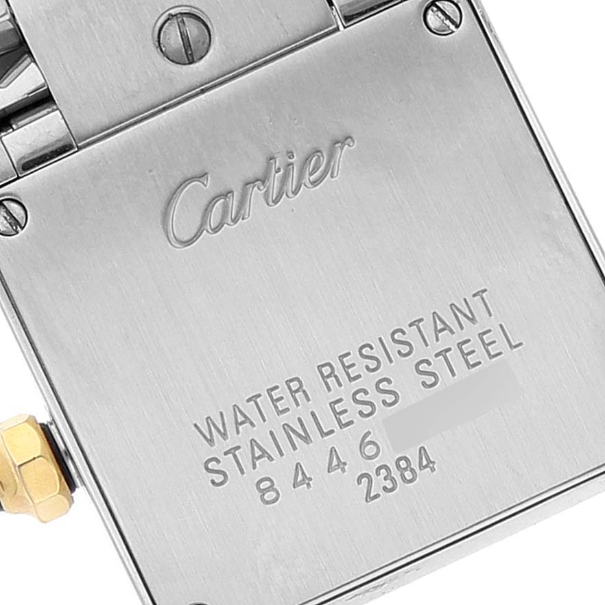 The image shows the back casing of a Cartier Tank Francaise W51007Q4 Women's Steel and Gold (two tone) Silver Dial W51007Q4 Women's Steel and Gold (two tone) Silver Dial watch, highlighting the engraving and metal screws.
