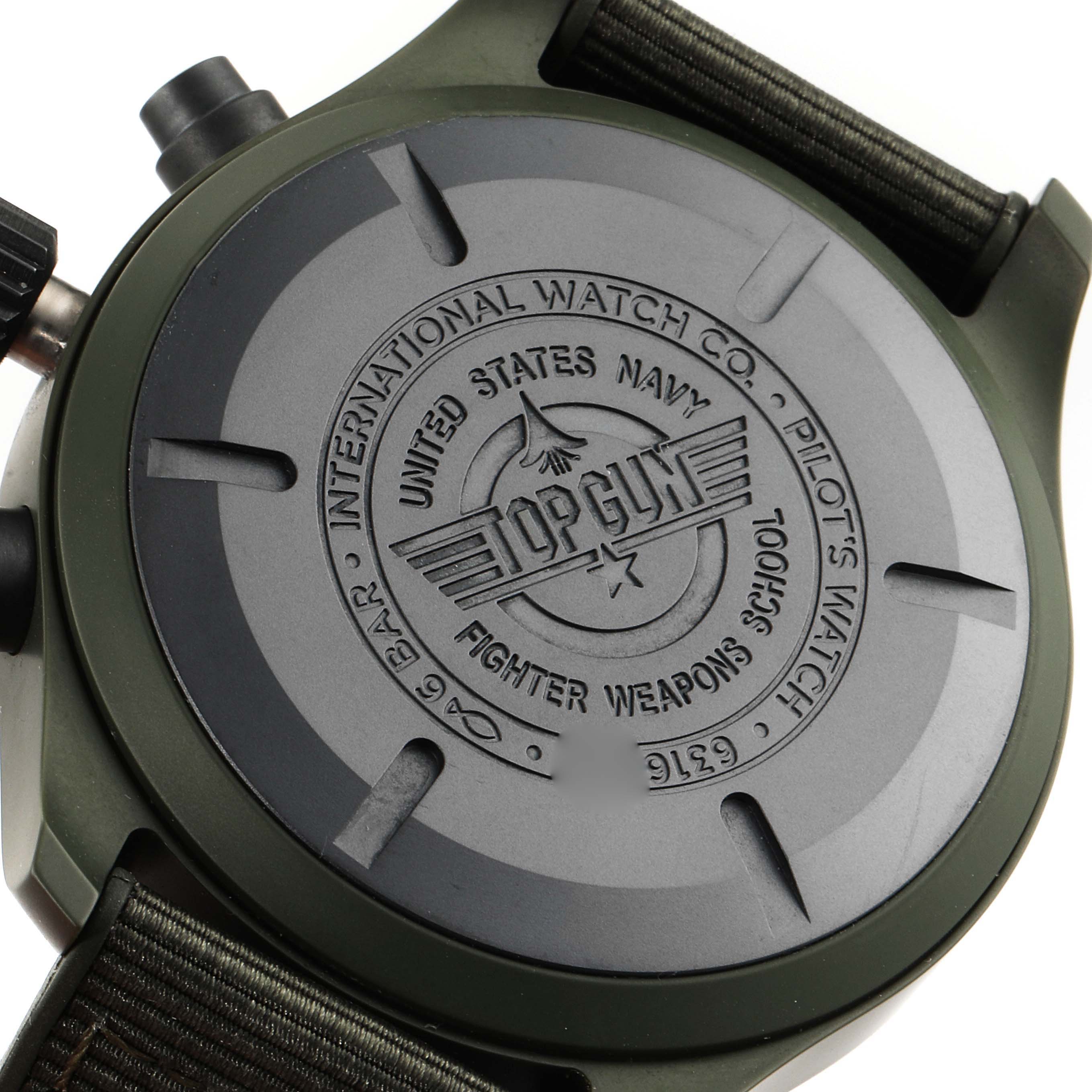 This image shows the case back of an IWC Pilot IW389106 Men's Ceramic Green Dial IW389106 Men's Ceramic Green Dial model watch, featuring branding for Top Gun and the United States Navy.