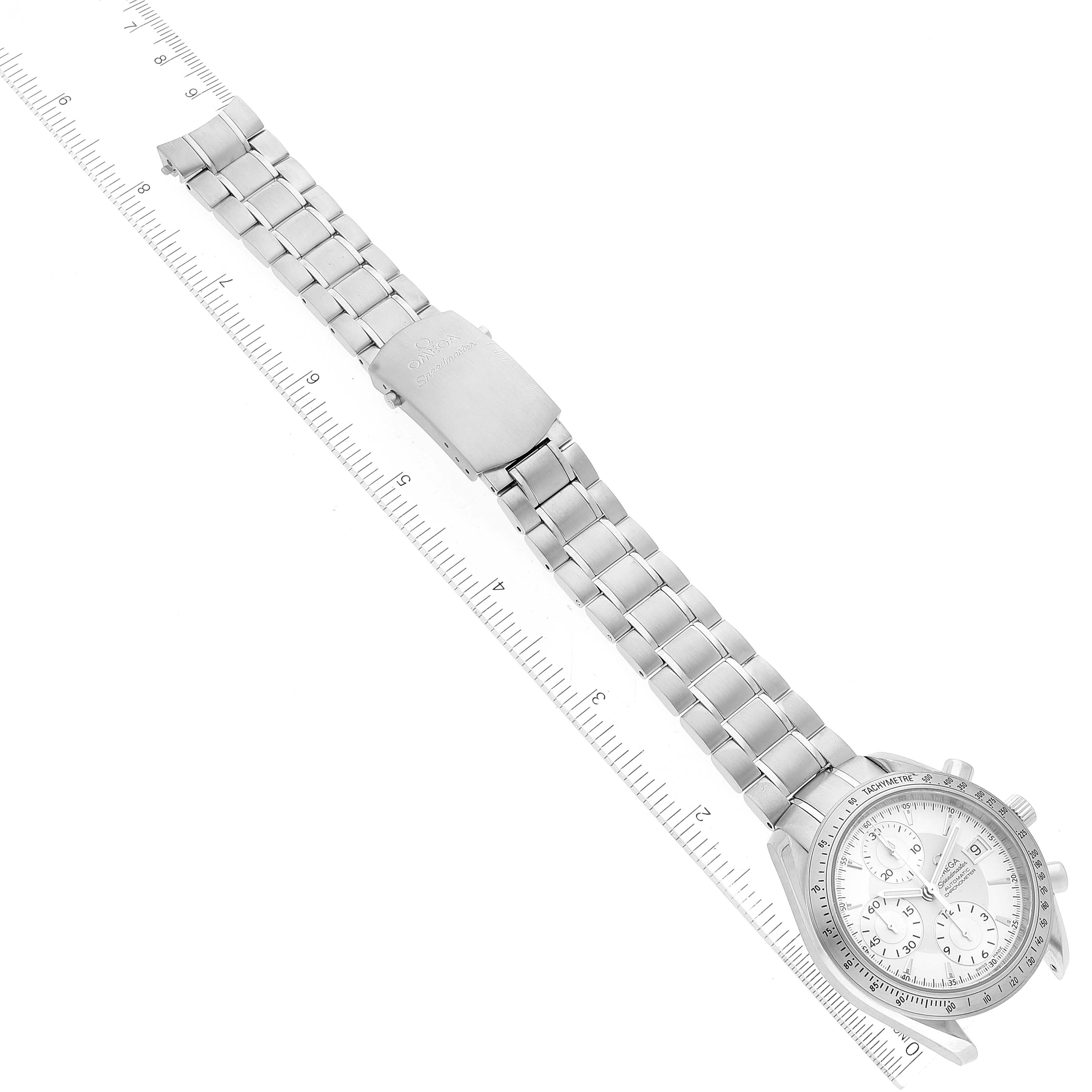 The Omega Speedmaster 3211.30.00 Men's Stainless Steel Silver Dial 3211.30.00 Men's Stainless Steel Silver Dial watch is shown from a top-down angle, displaying the face, bezel, and stainless steel bracelet against a ruler.