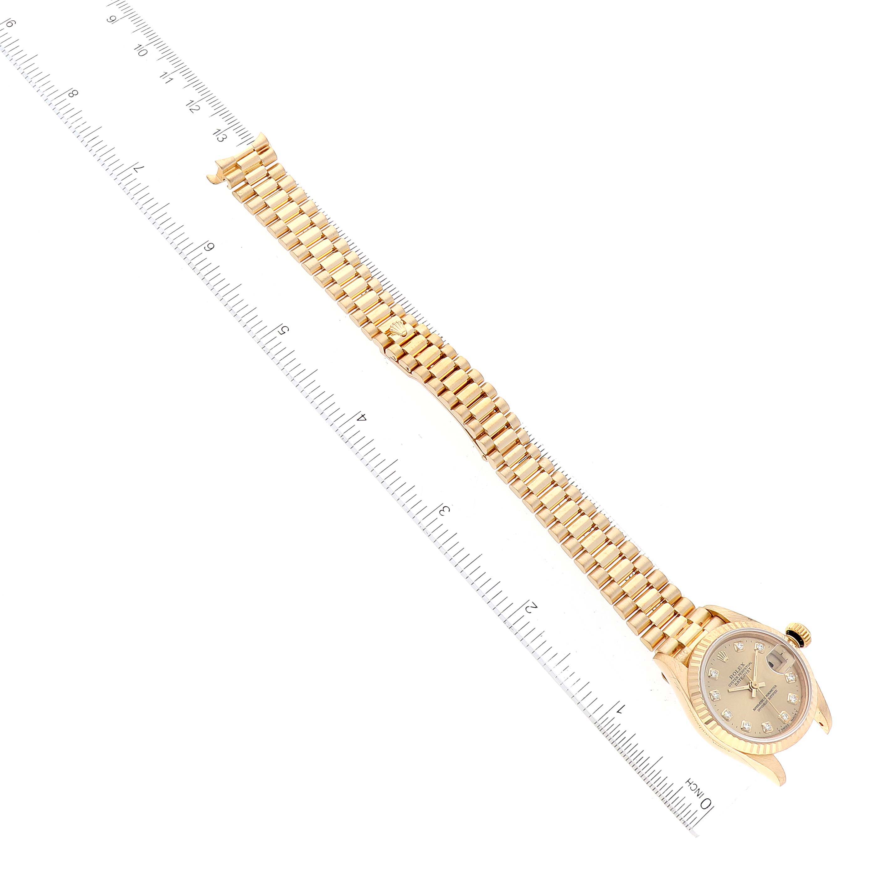 The image shows the Rolex President 69178 Women's Yellow Gold Champagne Dial 69178 Women's Yellow Gold Champagne Dial model watch laid flat with a ruler next to it, displaying its face and bracelet.