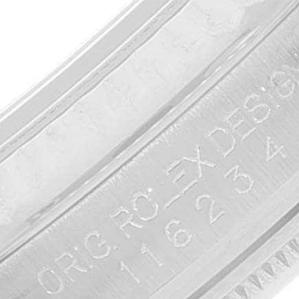 The image shows a close-up of the inner bezel of a Rolex Datejust 116234 Men's Stainless Steel Blue Dial 116234 Men's Stainless Steel Blue Dial model watch, displaying part of the engraving.