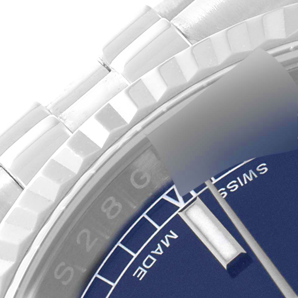 This close-up image of a Rolex Datejust 116234 Men's Stainless Steel Blue Dial 116234 Men's Stainless Steel Blue Dial watch shows the edge of the dial, part of the bracelet, and the fluted bezel.