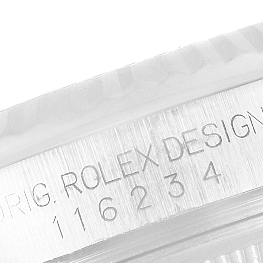 The image shows a close-up of the edge of the Rolex Datejust 116234 Men
s Stainless Steel Black Dial 116234 Men
s Stainless Steel Black Dial watch casing with the engraving "ROLEX DESIGN" and numbers.