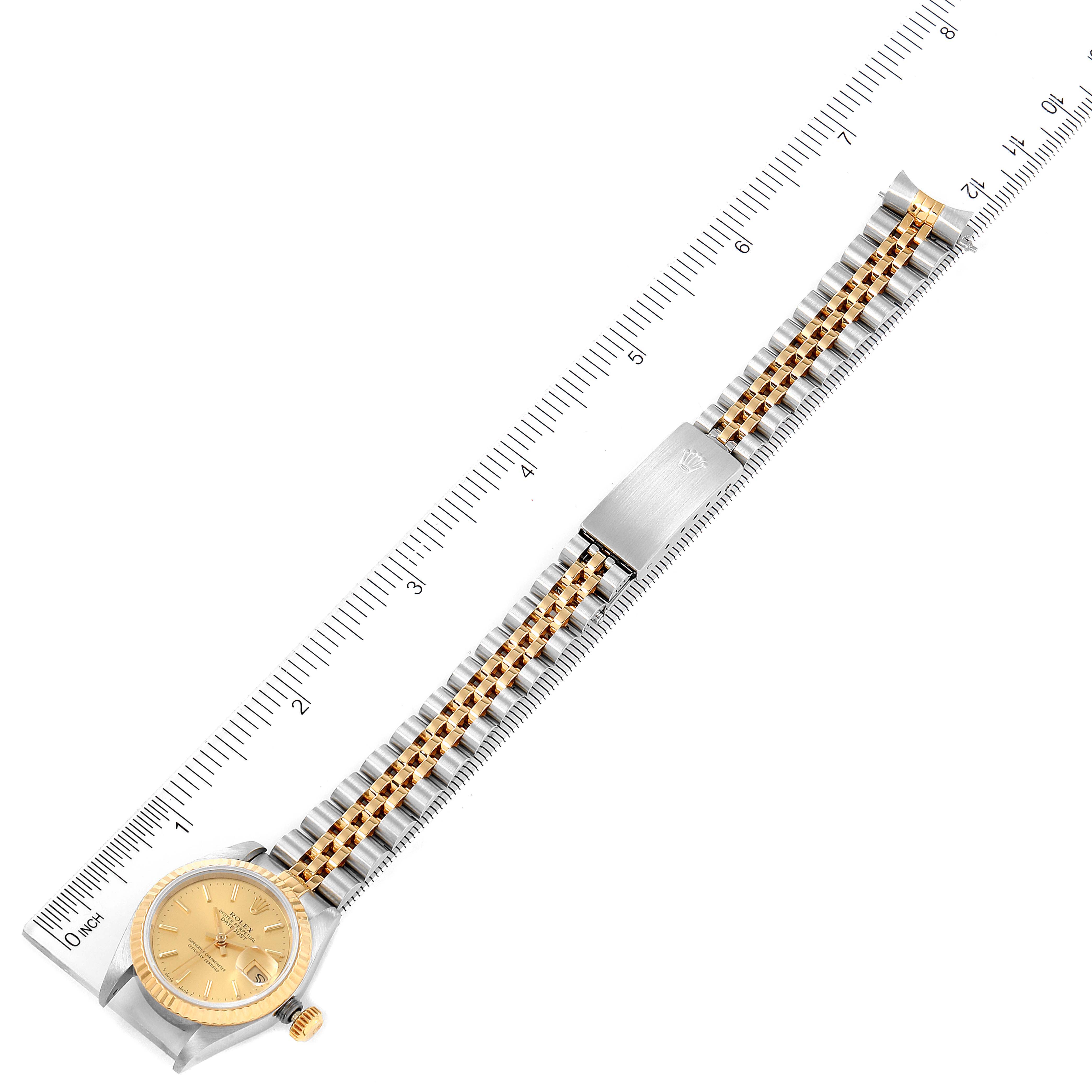 The image shows a Rolex Datejust 69173 Women
s Steel and Gold (two tone) Champagne Dial 69173 Women
s Steel and Gold (two tone) Champagne Dial watch from a top-down angle, displaying the gold dial, bezel, two-tone jubilee bracelet, and clasp.