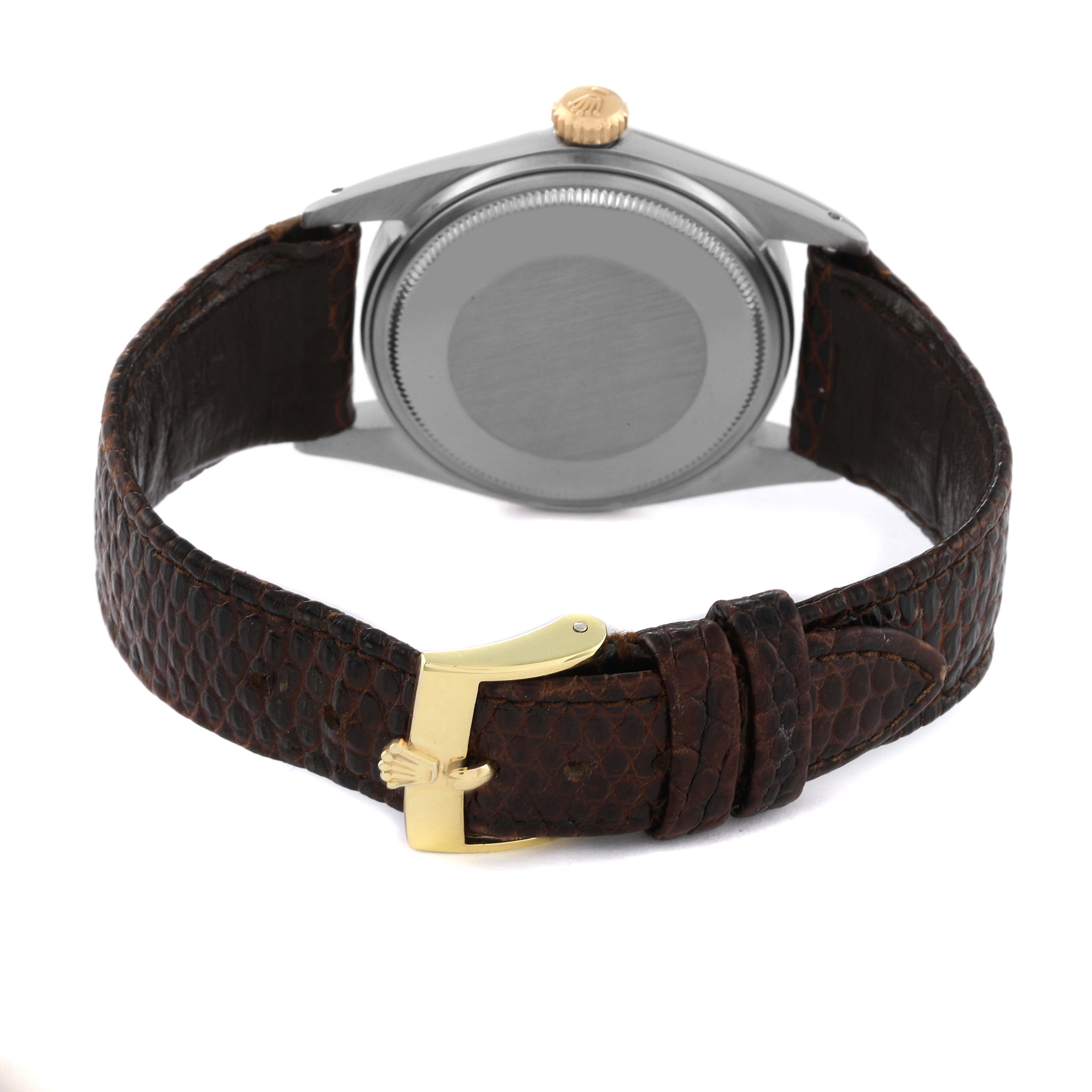 This image shows the backside of the Rolex Vintage Collection 1601 Men's Steel and Gold (two tone) Silver Dial 1601 Men's Steel and Gold (two tone) Silver Dial watch, highlighting its case back, crown, and leather strap with a gold buckle.