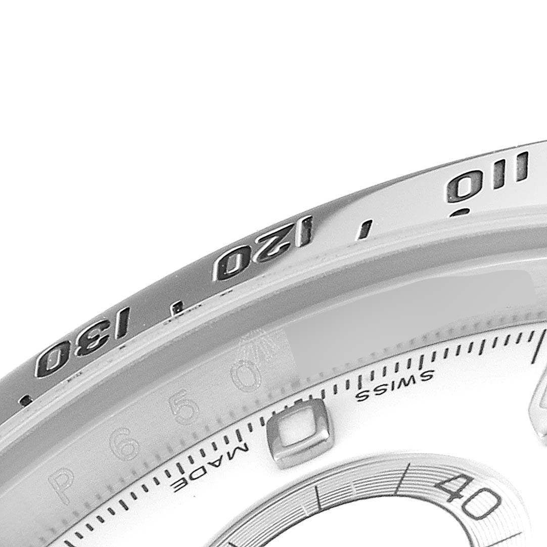 This close-up angled shot shows the bezel and part of the dial of a Rolex Daytona 116520 Men's Stainless Steel White Dial 116520 Men's Stainless Steel White Dial watch.