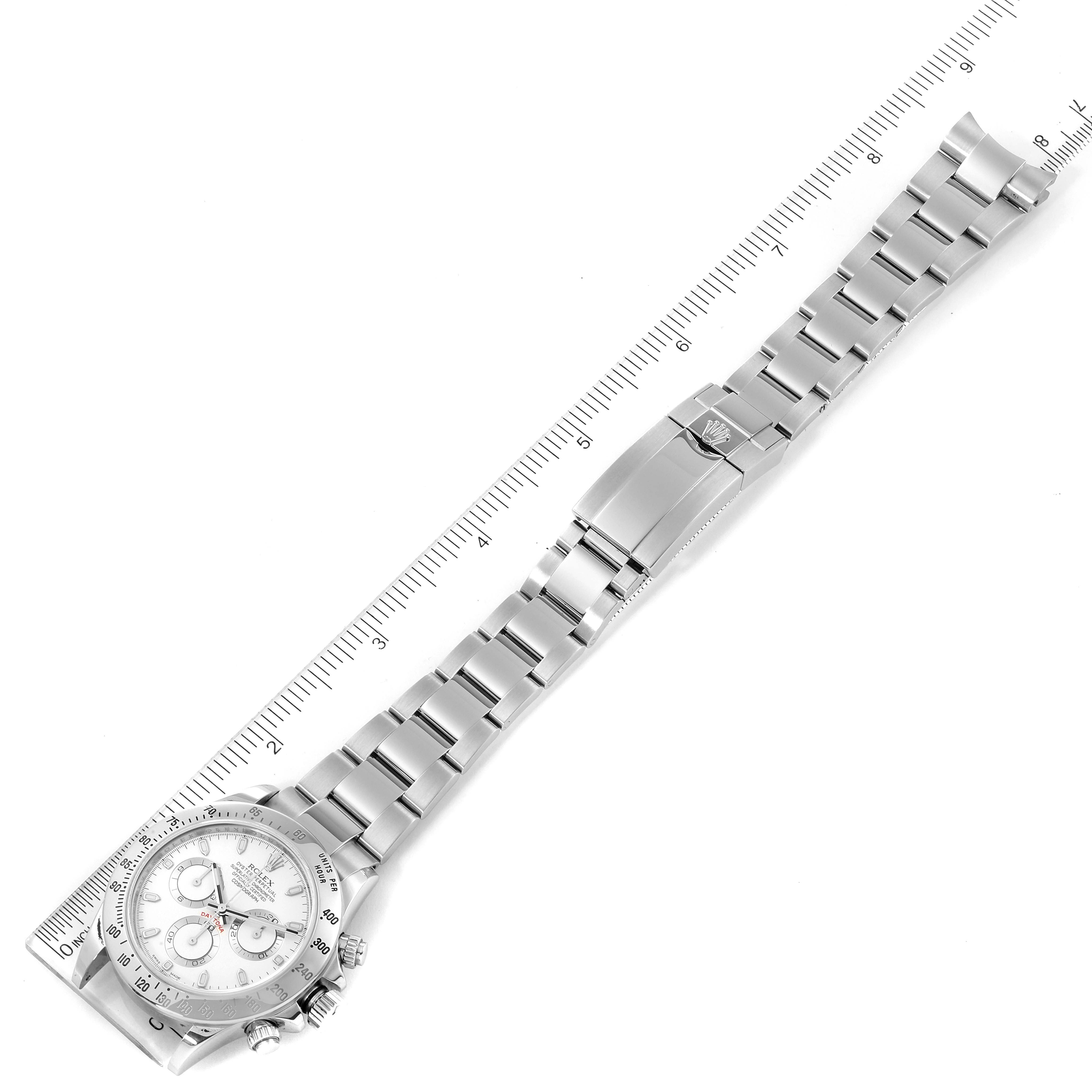 The image shows an overhead view of the Rolex Daytona 116520 Men's Stainless Steel White Dial 116520 Men's Stainless Steel White Dial watch, including the full bracelet and clasp, with a ruler for scale.