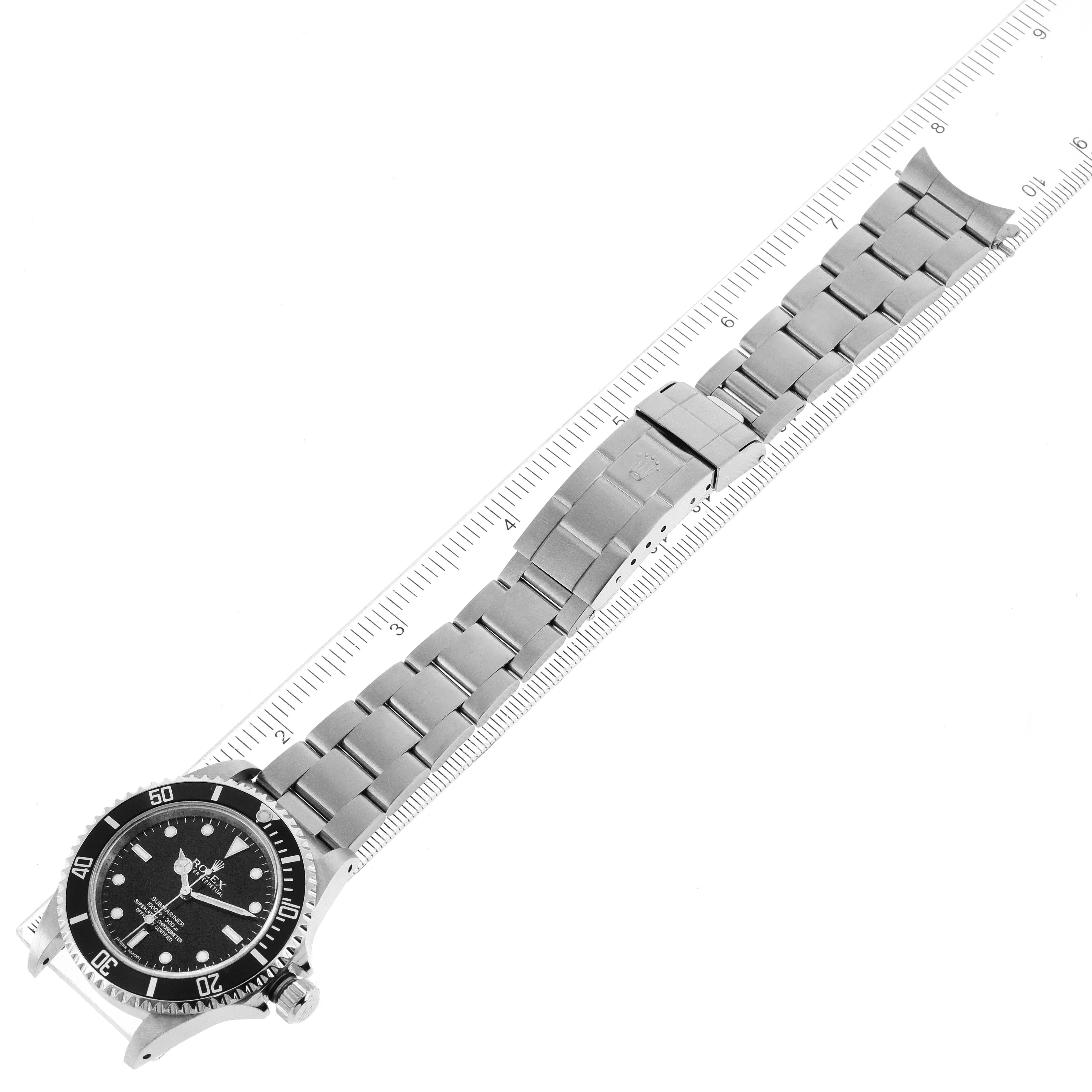 The image shows a full view of the Rolex Submariner 14060 Men's Stainless Steel Black Dial 14060 Men's Stainless Steel Black Dial watch, including its metal bracelet and clasp, placed next to a ruler for scale.