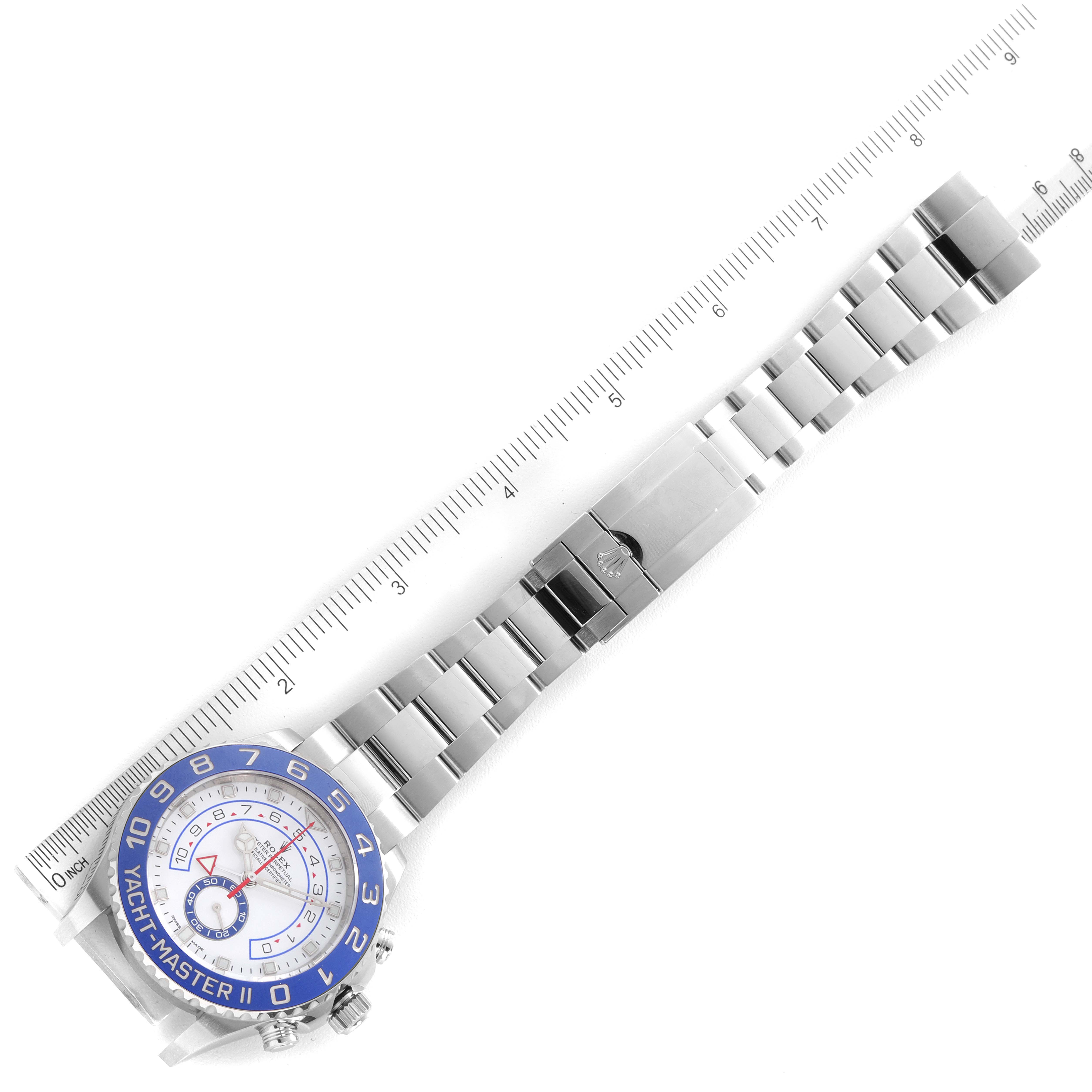 The image shows a top view of a Rolex Yacht-Master 116680 Men
s Stainless Steel White Dial 116680 Men
s Stainless Steel White Dial II watch and its bracelet next to a measuring ruler.