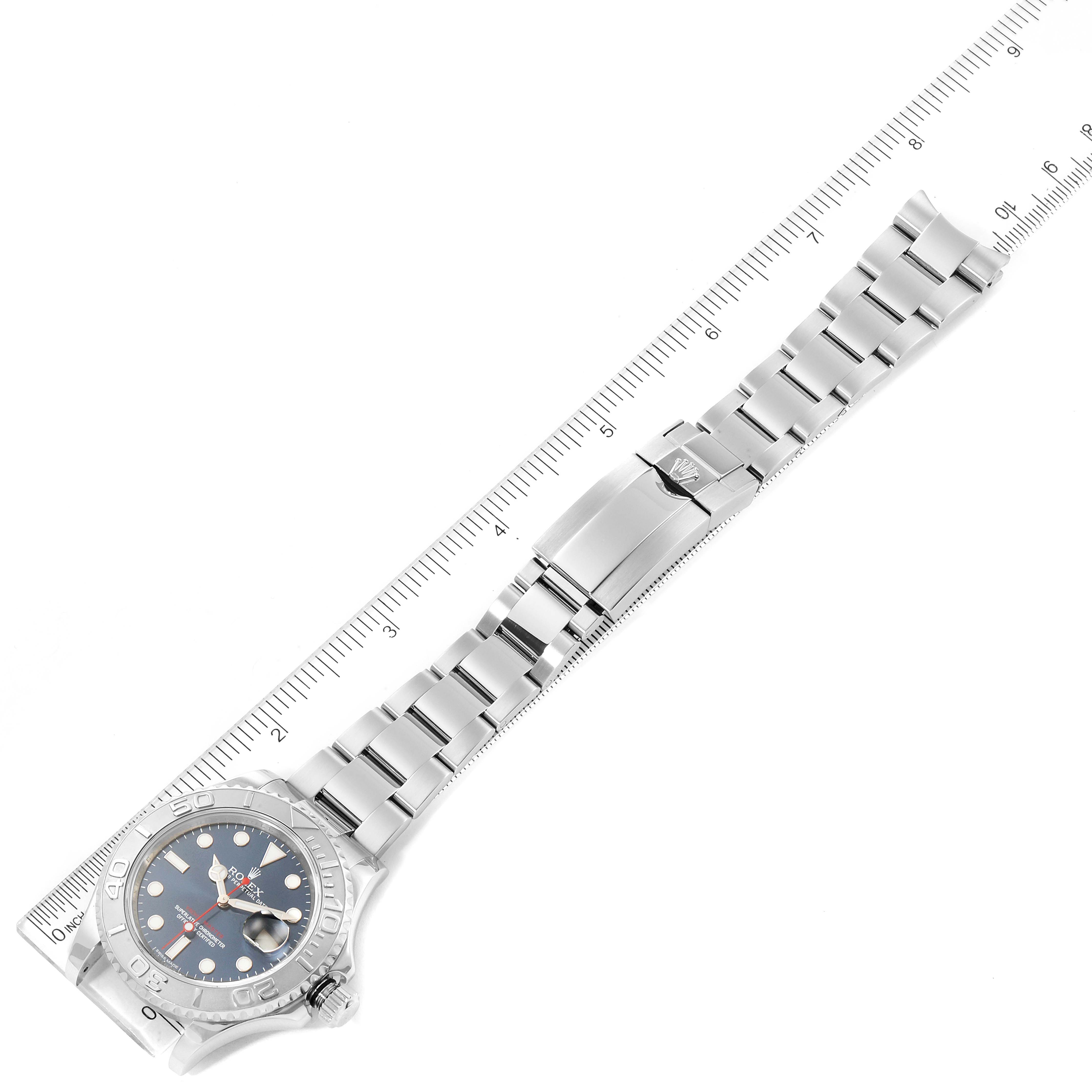 The Rolex Yacht-Master 116622 Men
s Stainless Steel Blue Dial 116622 Men
s Stainless Steel Blue Dial watch is displayed flat, including the full bracelet and clasp, alongside a measuring ruler.
