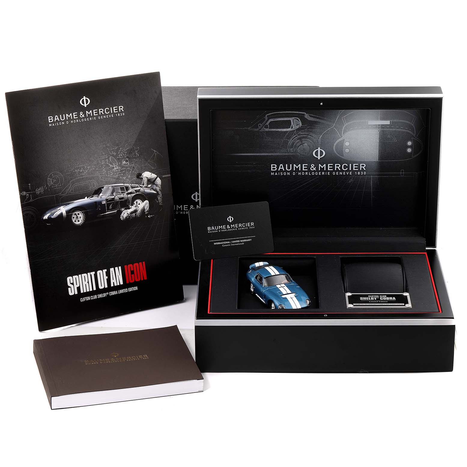 A Baume & Mercier Clifton M0A10342 Men's Stainless Steel Blue Dial M0A10342 Men's Stainless Steel Blue Dial watch set shown in a box with a booklet, model car, and display card from a front angle.
