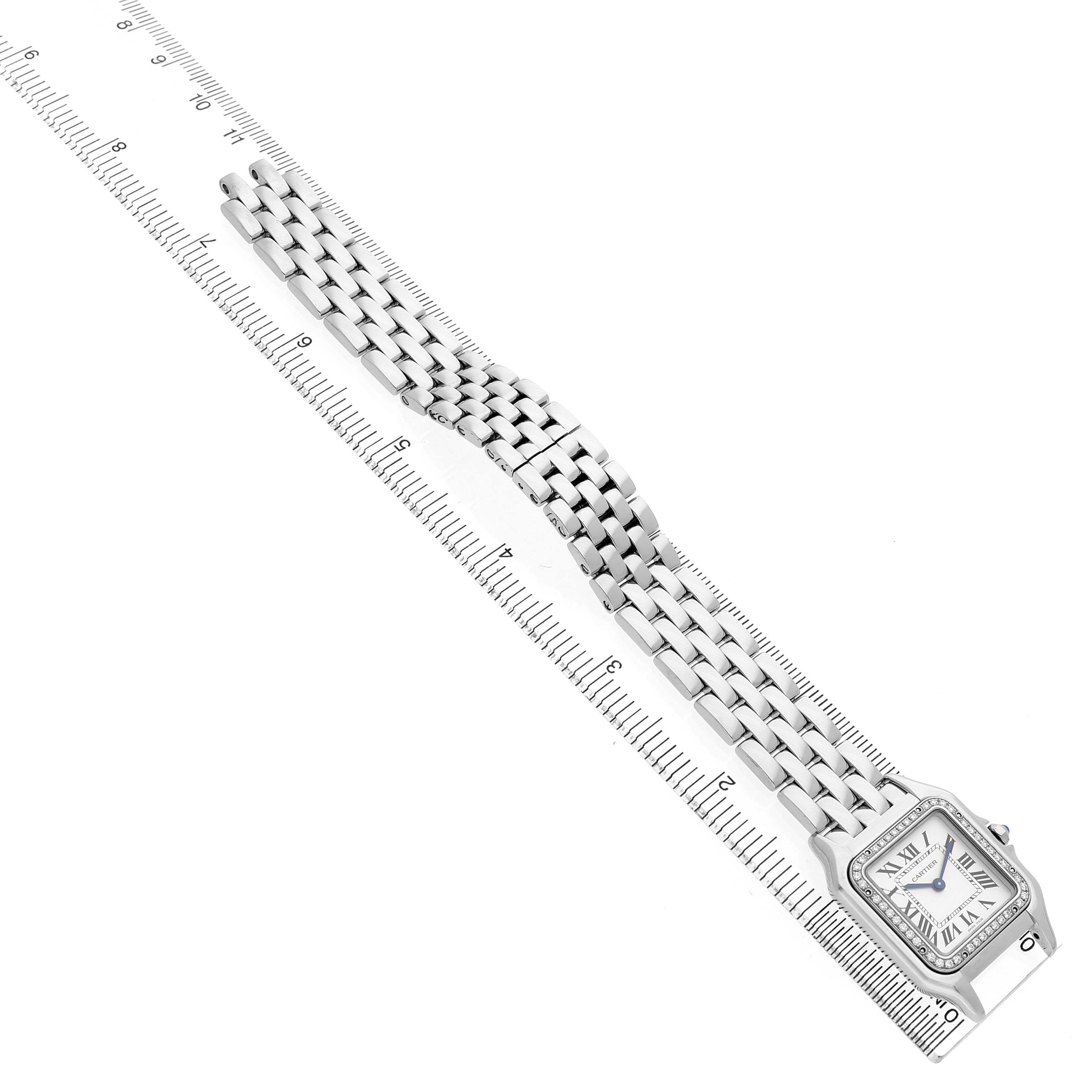 The Cartier Panthere W4PN0008 Women's Stainless Steel Silver Dial watch is shown at an angled top view, displaying the watch face and bracelet laid on a ruler for scale.