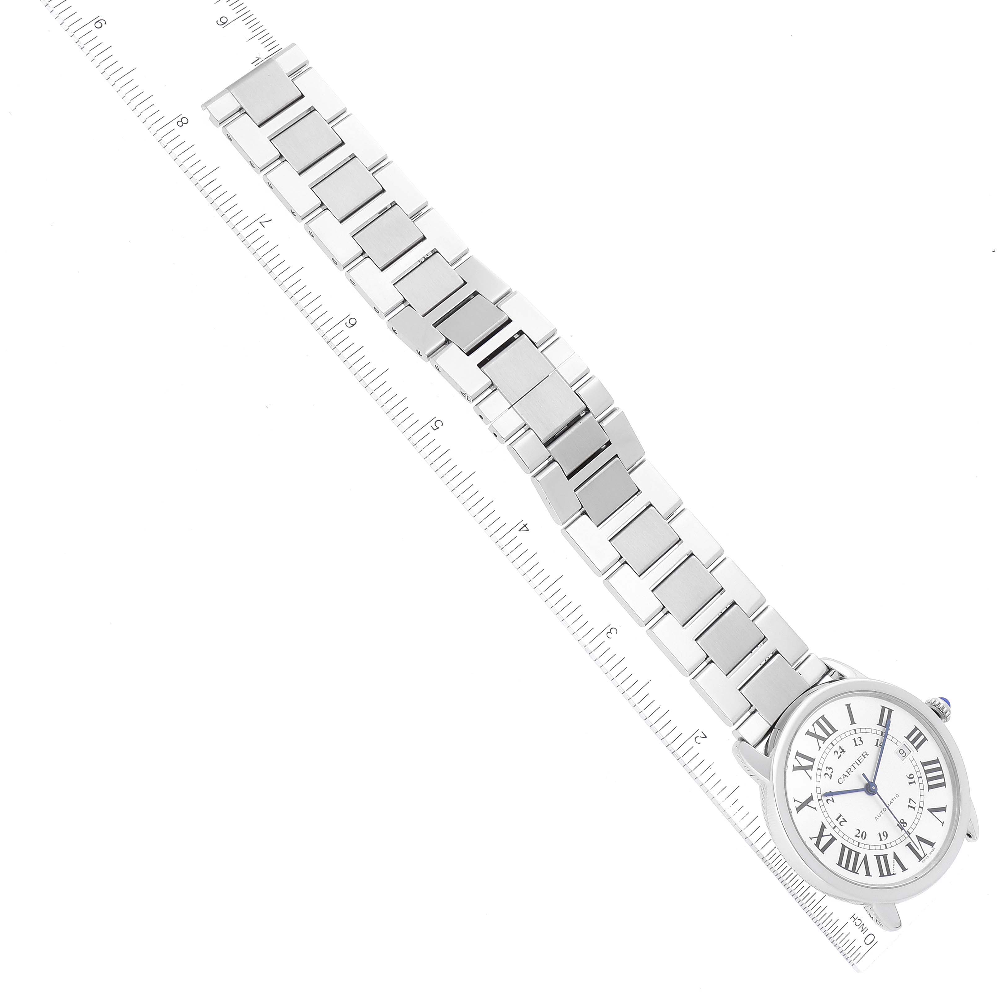 The image shows a Cartier Ronde W6701011 Men
s Stainless Steel Silver Dial W6701011 Men
s Stainless Steel Silver Dial watch at an angled top view, focusing on its face and silver bracelet with a ruler beside it.