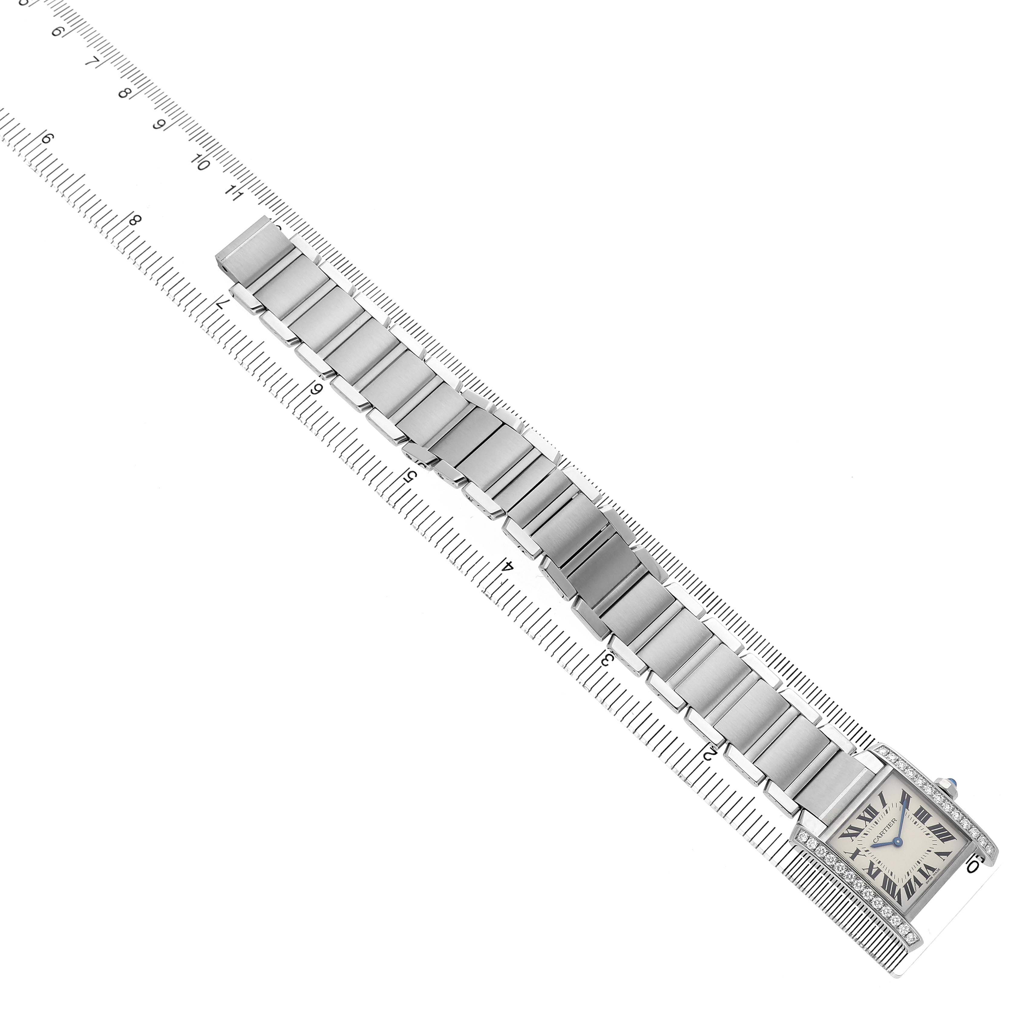The Cartier Tank Francaise W4TA0009 Women's Stainless Steel Silver Dial watch is shown from a top-down angle, displaying the face and metal bracelet alongside a ruler for scale.