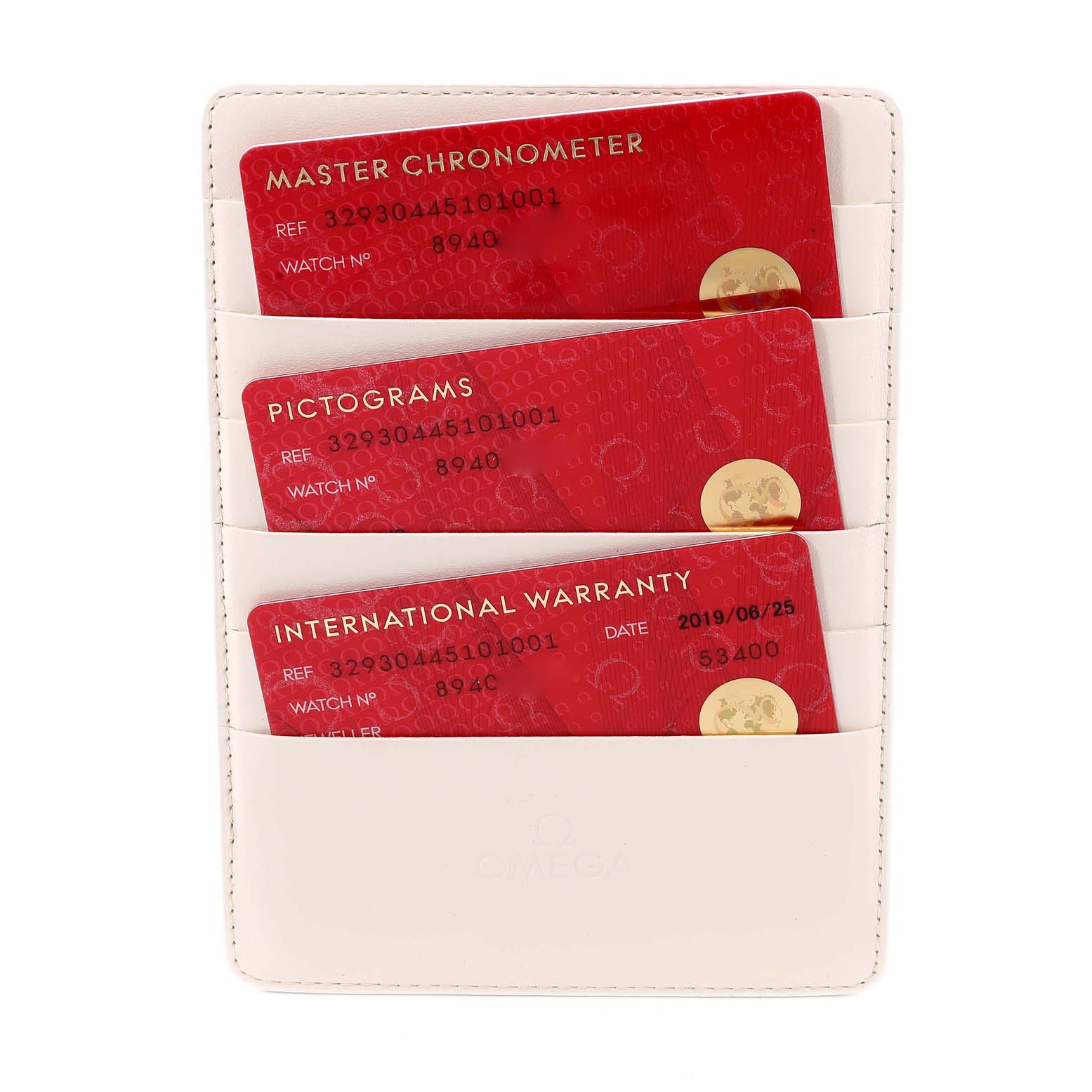 The image shows a white leather card holder with three red cards for an Omega Speedmaster 329.30.44.51.01.001 Men's Stainless Steel Black Dial 329.30.44.51.01.001 Men's Stainless Steel Black Dial watch, including Master Chronometer, Pictograms, and International Warranty cards.