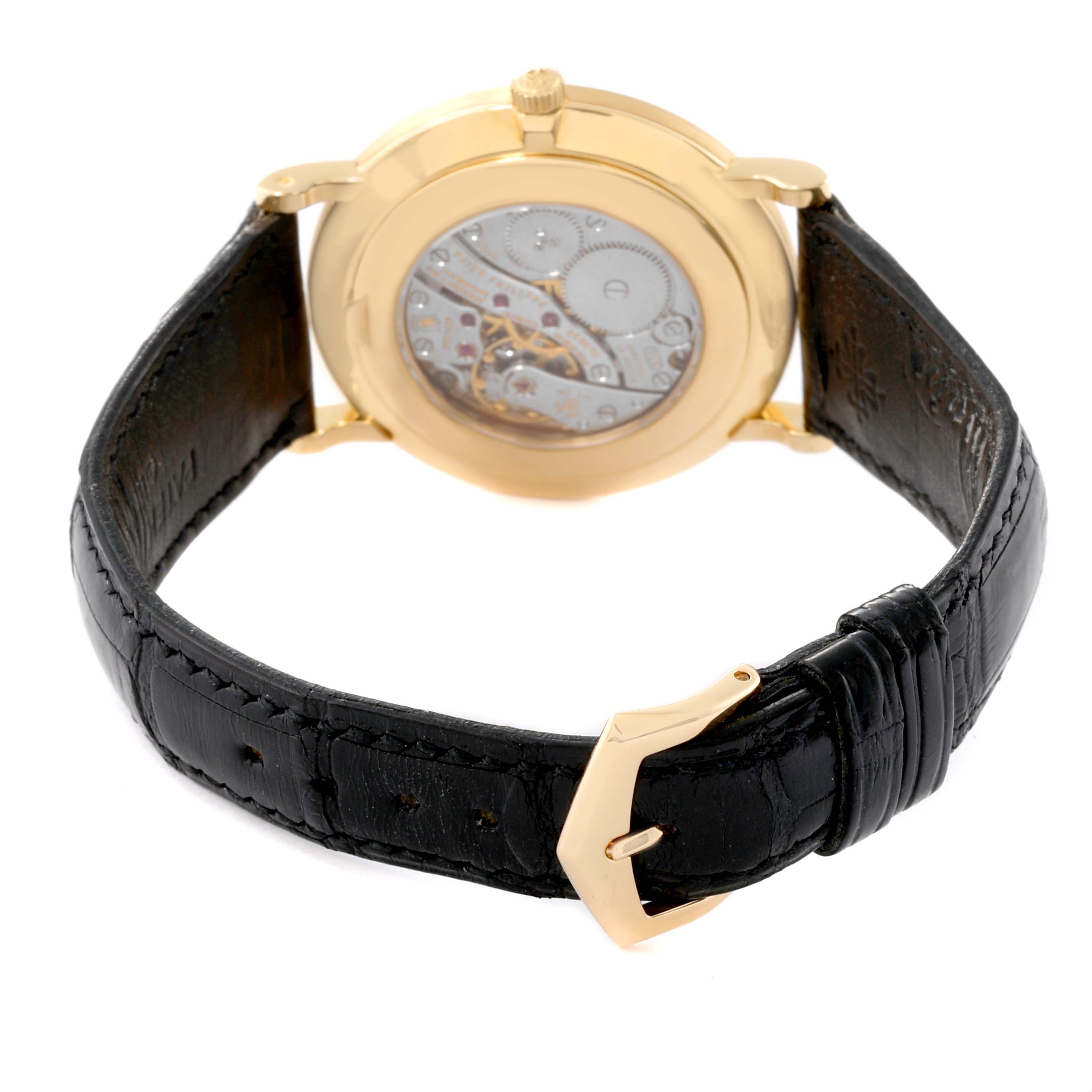 The image shows the back view of the Patek Philippe Calatrava 5119J Men's Yellow Gold White Dial 5119J Men's Yellow Gold White Dial watch, highlighting its inner mechanism and black leather strap.