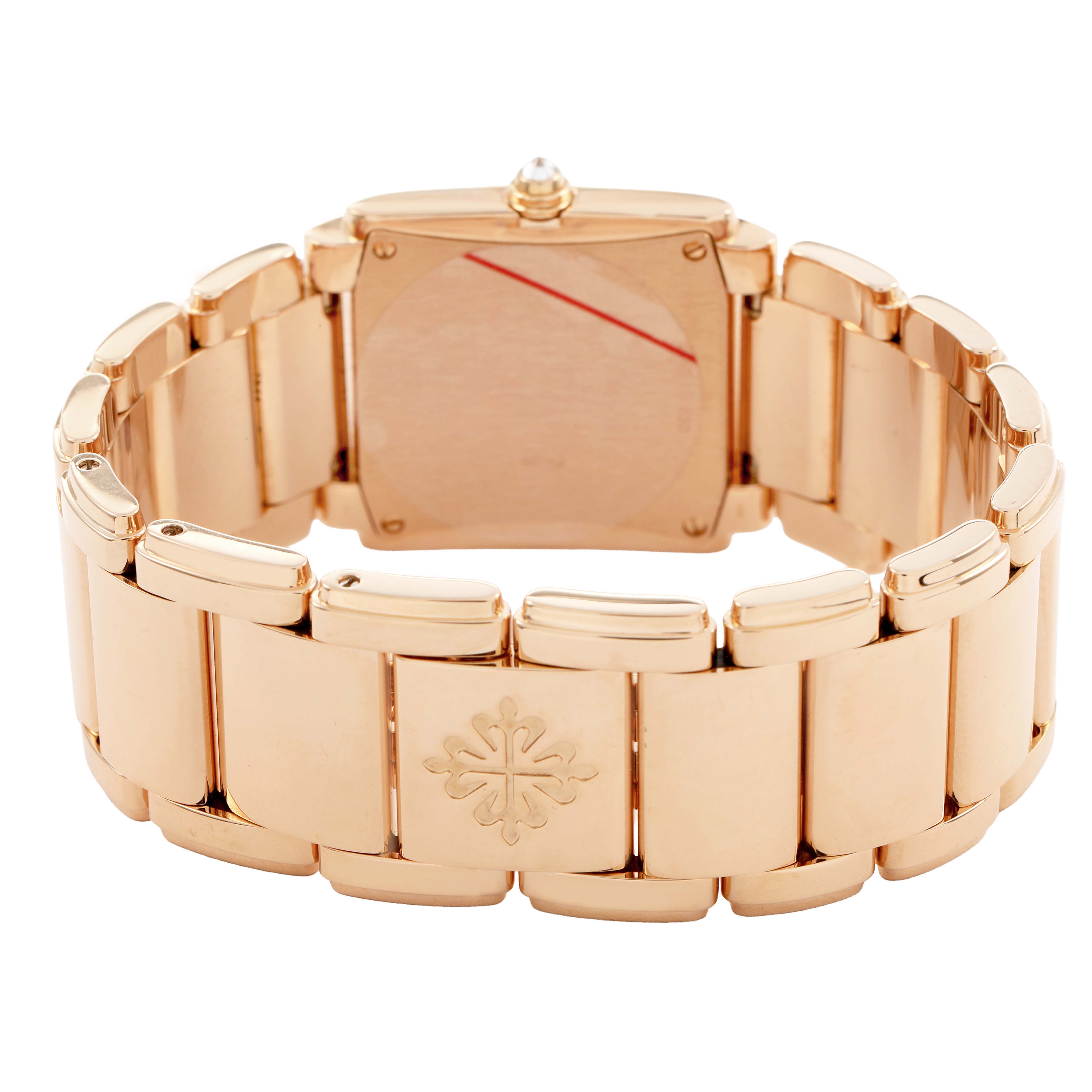The image shows the back and bracelet of a Patek Philippe Twenty-4 4910/11R-011 Women's Rose Gold Silver Dial watch, highlighting its emblem and gold-tone links.