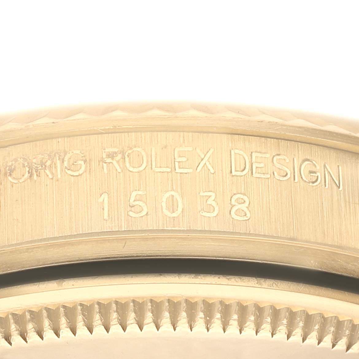 This close-up image shows the side of a Rolex Date 15038 Men's Yellow Gold Champagne Dial 15038 Men's Yellow Gold Champagne Dial watch case, focusing on the model number 15038 and the engraving "ORIG ROLEX DESIGN."