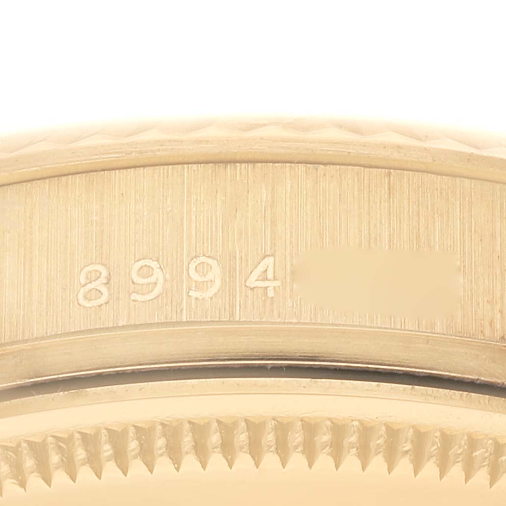 This close-up image shows the bezel and the serial number details of a Rolex Date 15038 Men's Yellow Gold Champagne Dial 15038 Men's Yellow Gold Champagne Dial model watch.