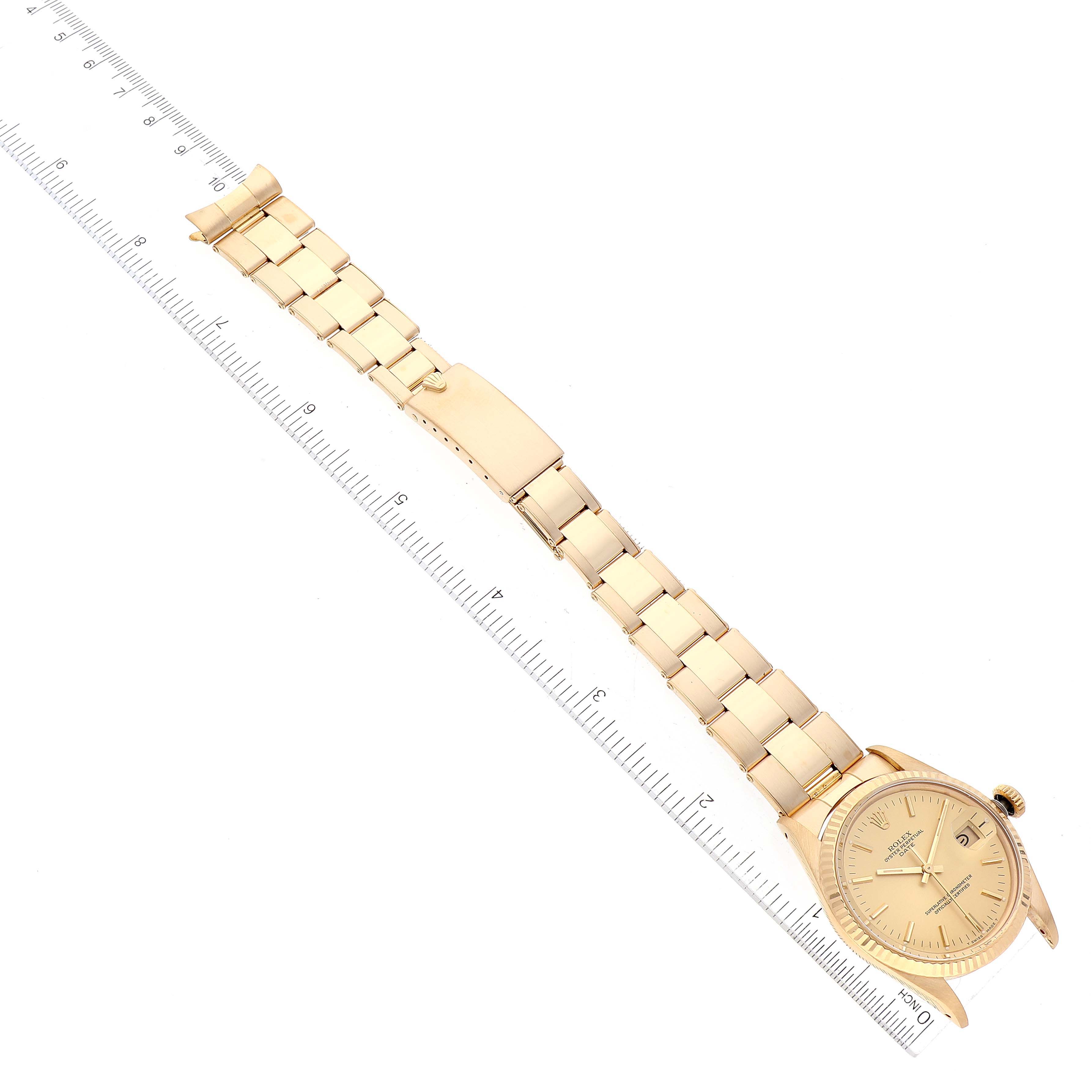This image shows a full-length view of a gold Rolex Date 15038 Men's Yellow Gold Champagne Dial 15038 Men's Yellow Gold Champagne Dial model watch, including the dial, bracelet, and clasp, with a ruler alongside.