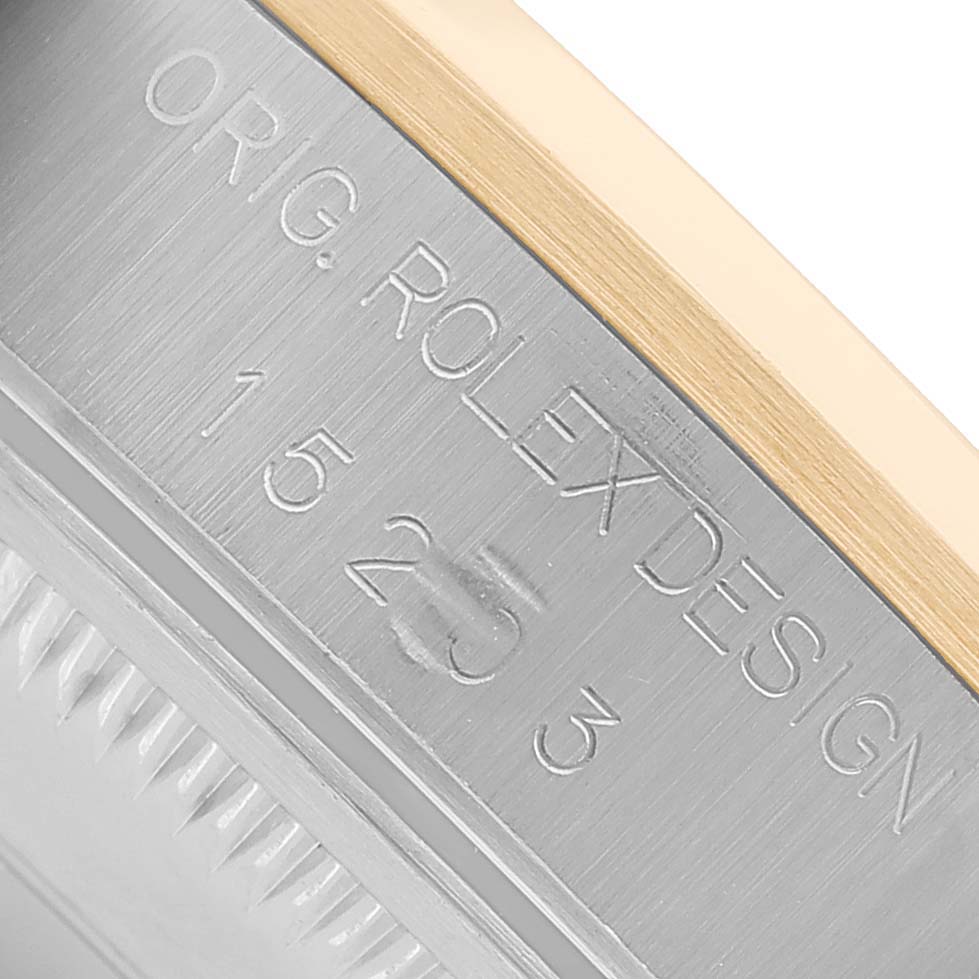 The image shows a close-up of the engraved side of a Rolex Date 15203 Men's Steel and Gold (two tone) White Dial watch case with part of the bezel visible.