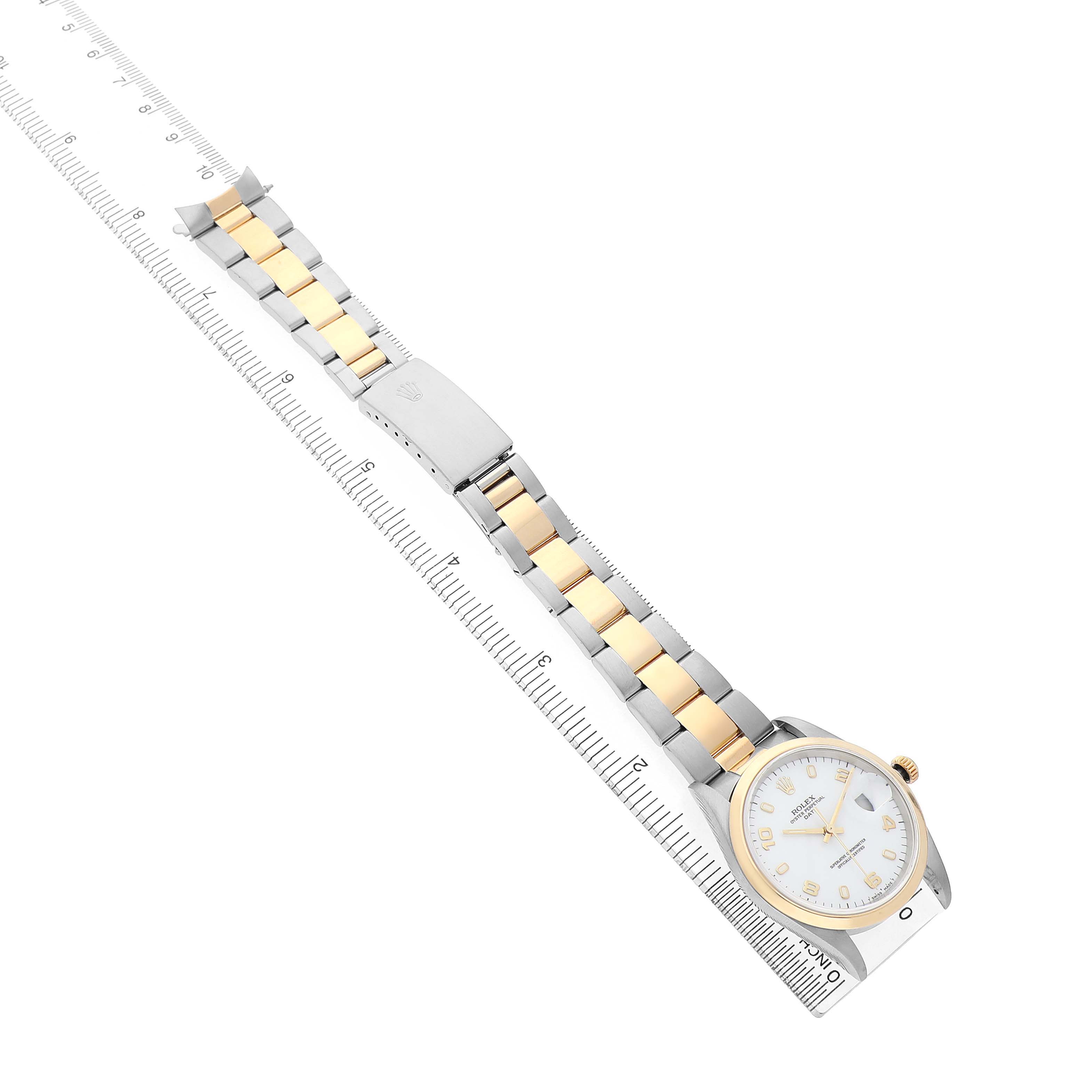 The image shows a Rolex Date 15203 Men's Steel and Gold (two tone) White Dial watch laid flat, featuring its dial, bezel, and linked bracelet, aligned with a ruler.