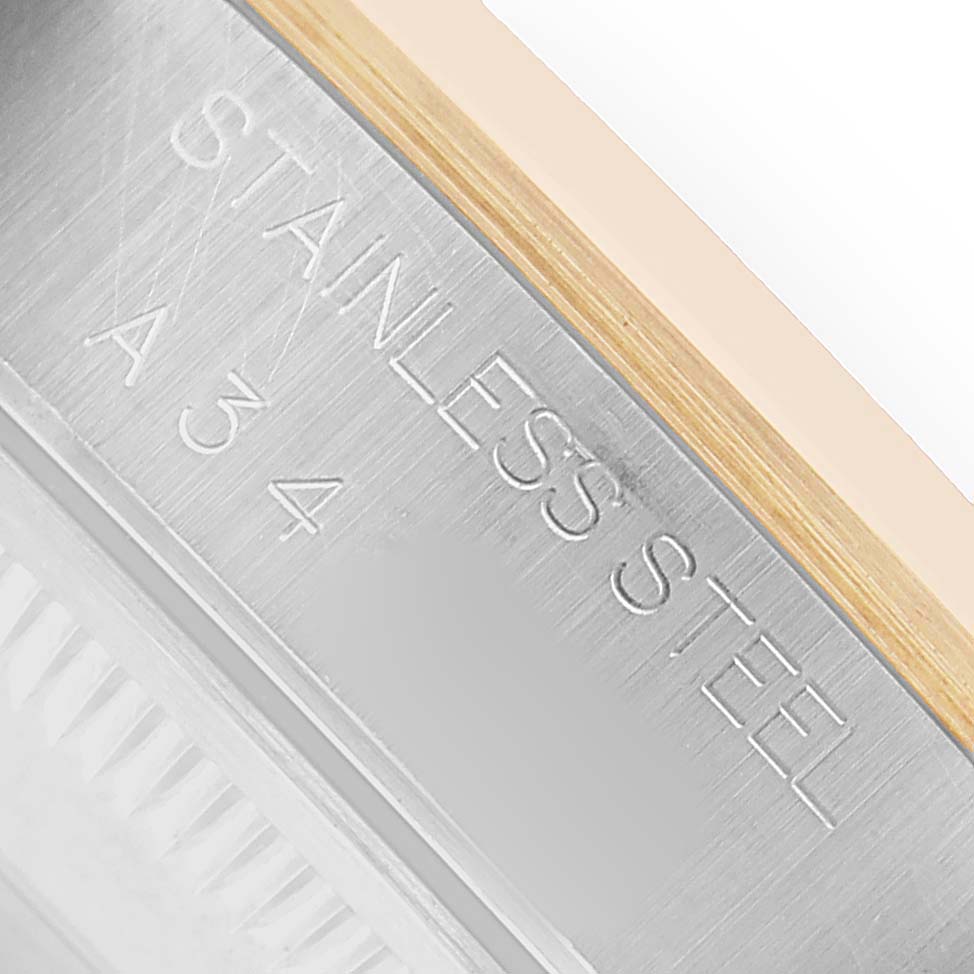 The image shows a close-up of the case side of a Rolex Date 15203 Men's Steel and Gold (two tone) White Dial watch, highlighting the "STAINLESS STEEL" engraving.