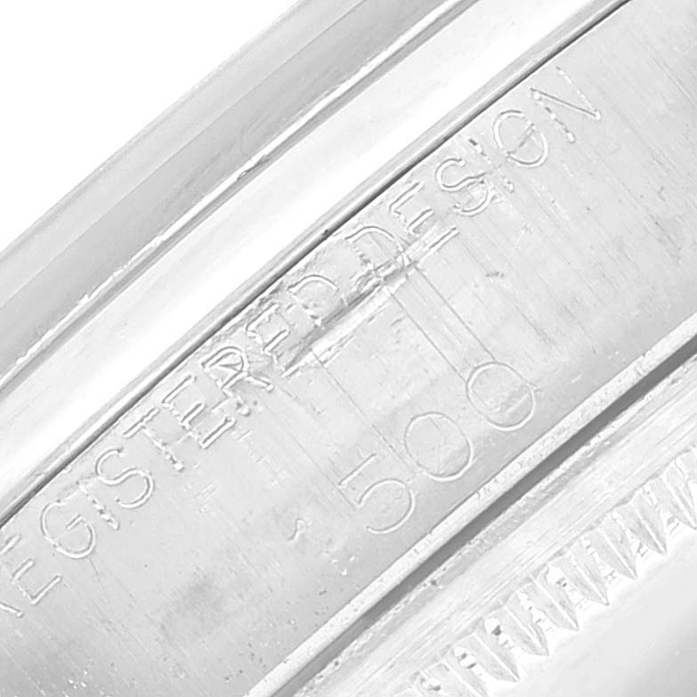 The image shows a close-up of the case of a Date model Rolex watch, highlighting the "REGISTERED DESIGN" engraving.