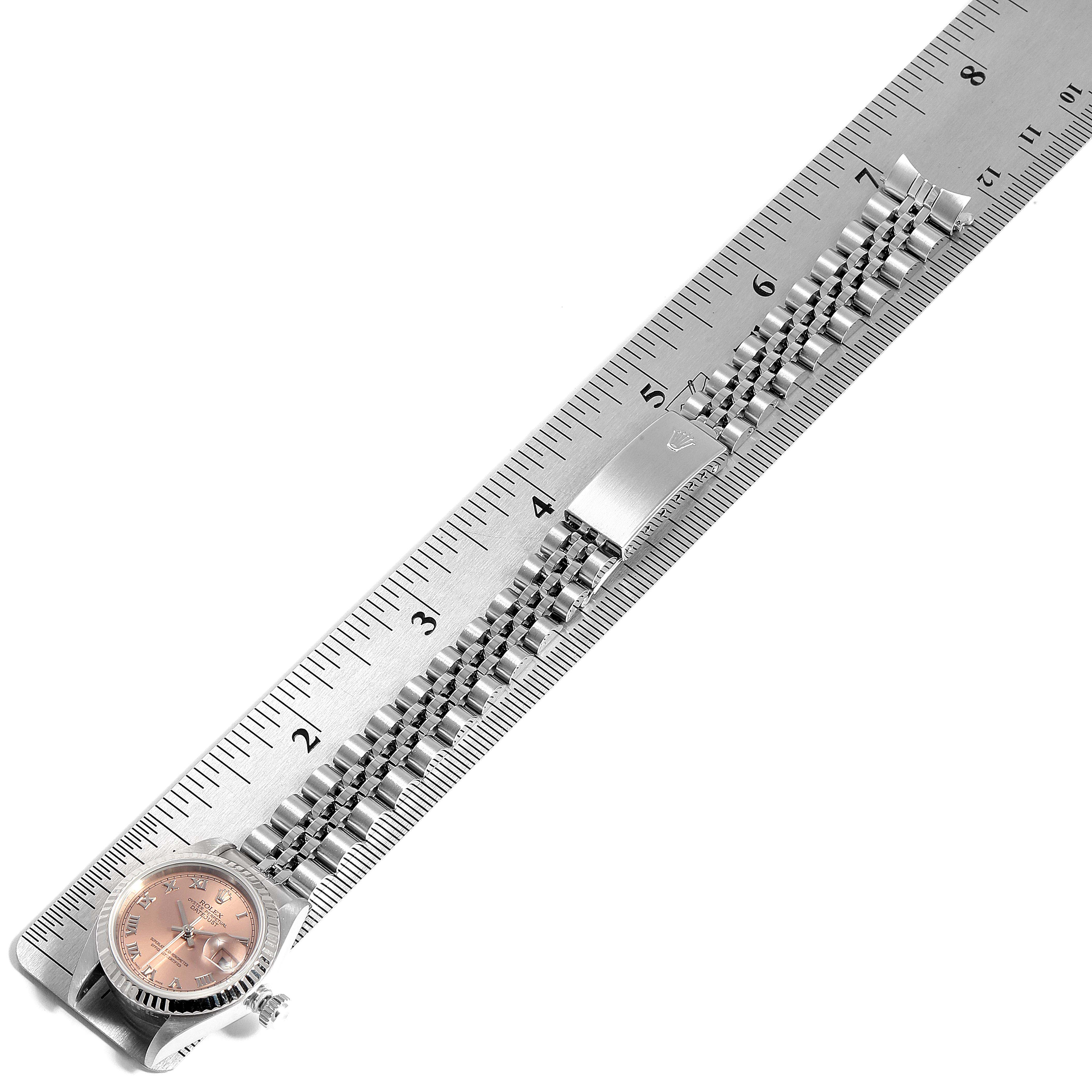The image shows a Rolex Datejust 69174 Women
s Stainless Steel Pink Dial 69174 Women
s Stainless Steel Pink Dial watch from the top, measuring its bracelet length with a ruler.