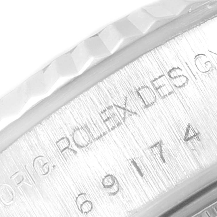 The image shows a close-up of the engraved inner bezel and fluted bezel of a Rolex Datejust 69174 Women
s Stainless Steel Pink Dial 69174 Women
s Stainless Steel Pink Dial watch.