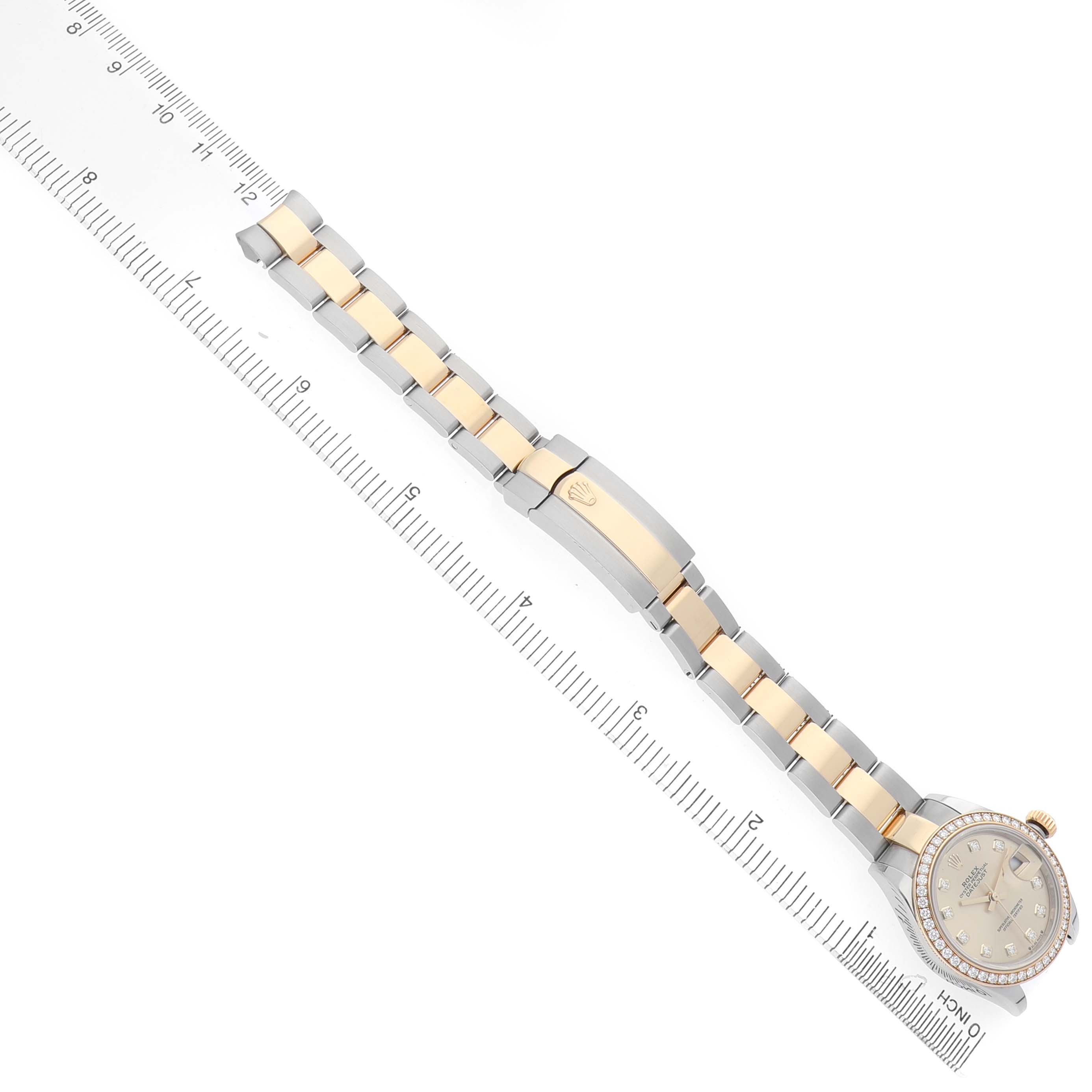 The image shows a Rolex Datejust 279383 Women's Steel and Gold (two tone) Champagne Dial watch from a top-down angle, highlighting the bracelet, clasp, and dial against a ruler.