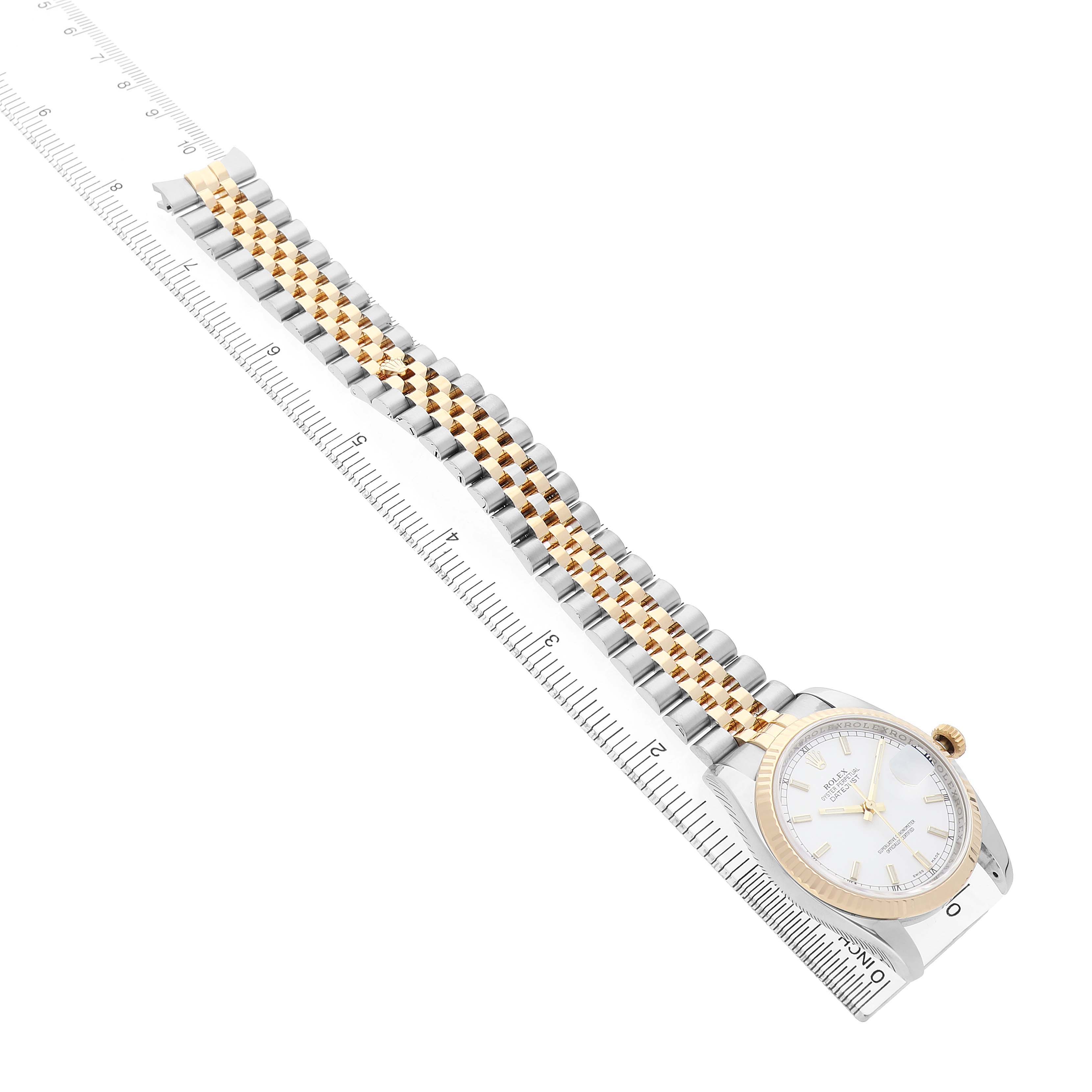 The Rolex Datejust 116233 Men's Steel and Gold (two tone) White Dial watch is shown at a diagonal angle, displaying the face, bezel, and two-tone bracelet alongside a measuring ruler.