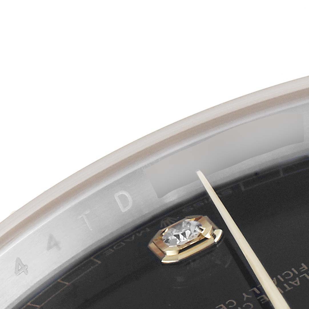 This close-up image of the Rolex Datejust 41 126333 Men's Steel and Gold (two tone) Black Dial 126333 Men's Steel and Gold (two tone) Black Dial watch shows the dial edge, a diamond hour marker, and part of the hands.