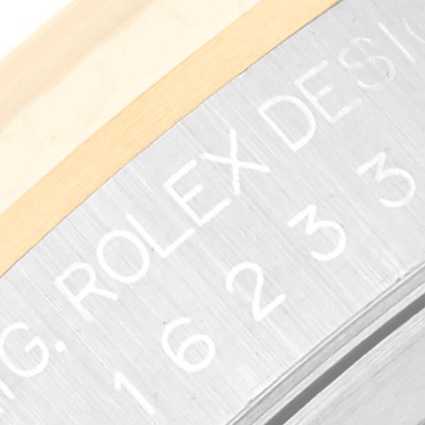 This image shows a close-up of the engraved side case of a Rolex Datejust 16233 Men's Steel and Gold (two tone) Champagne Dial 16233 Men's Steel and Gold (two tone) Champagne Dial watch, displaying part of the model number.