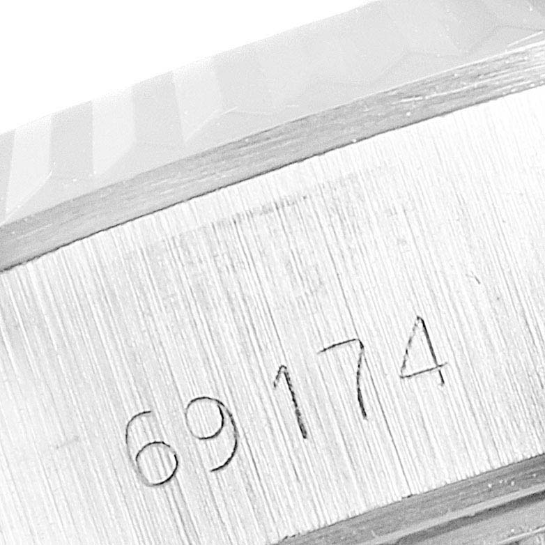 The image shows a close-up of the serial number on the side of a Rolex Datejust 69174 Women's Stainless Steel Silver Dial 69174 Women's Stainless Steel Silver Dial watch's case.