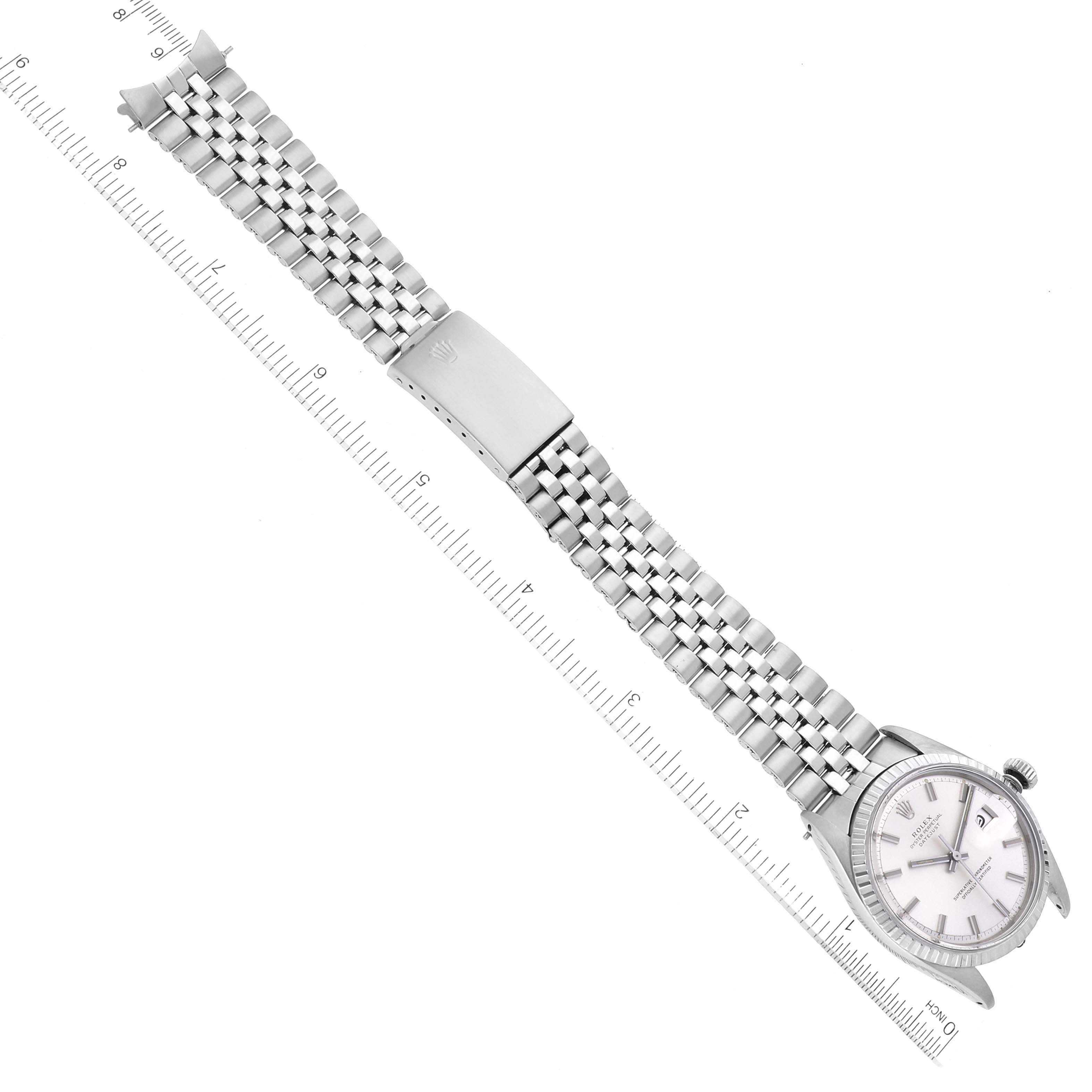 The image shows a top-down view of a Rolex Datejust 1601 Men's Stainless Steel Silver Dial 1601 Men's Stainless Steel Silver Dial watch with its face and full bracelet aligned next to a ruler.