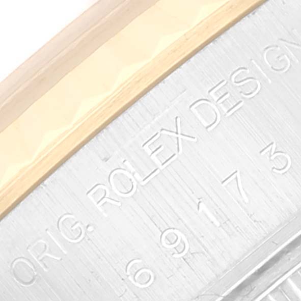 This image shows a close-up angle of the engraved "ROLEX DESIGN" text on the bezel of a Rolex Datejust 69173 Women's Steel and Gold (two tone) Beige Dial 69173 Women's Steel and Gold (two tone) Beige Dial watch.