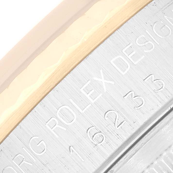 This close-up image of a Rolex Datejust 16233 Men's Steel and Gold (two tone) Black Dial 16233 Men's Steel and Gold (two tone) Black Dial watch shows part of the bezel and the engraved side of the case.