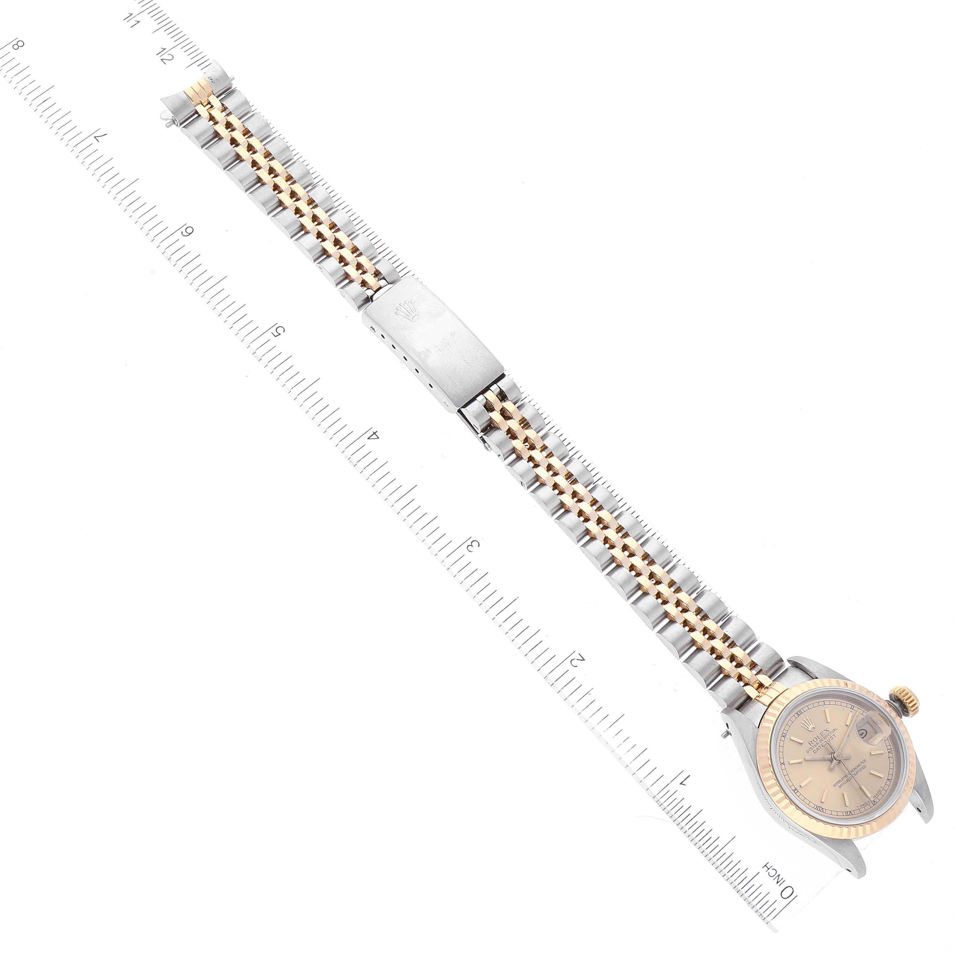 The image shows a Rolex Datejust 69173 Women's Steel and Gold (two tone) Champagne Dial 69173 Women's Steel and Gold (two tone) Champagne Dial watch from a top-down angle, highlighting its dial, bracelet, and clasp against a ruler for scale.
