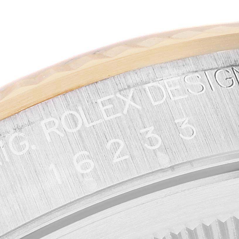This close-up image shows the edge of the case and the engraved lettering "ROLEX DESIGN" on a Rolex Datejust 16233 Men's Steel and Gold (two tone) Mother of Pearl Dial 16233 Men's Steel and Gold (two tone) Mother of Pearl Dial model.