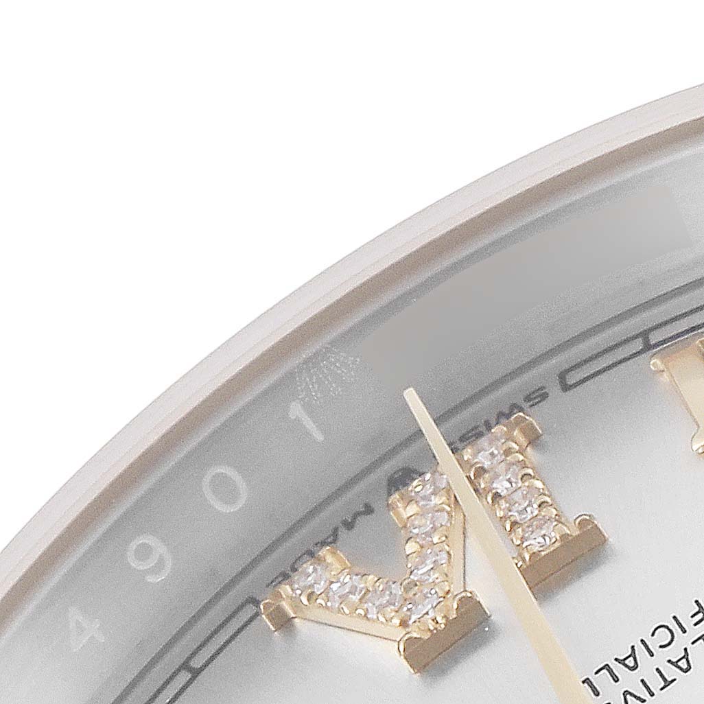 This close-up shows the bezel and part of the dial of a Rolex Datejust 126233 Men's Steel and Gold (two tone) Silver Dial 126233 Men's Steel and Gold (two tone) Silver Dial with diamond-encrusted Roman numerals.