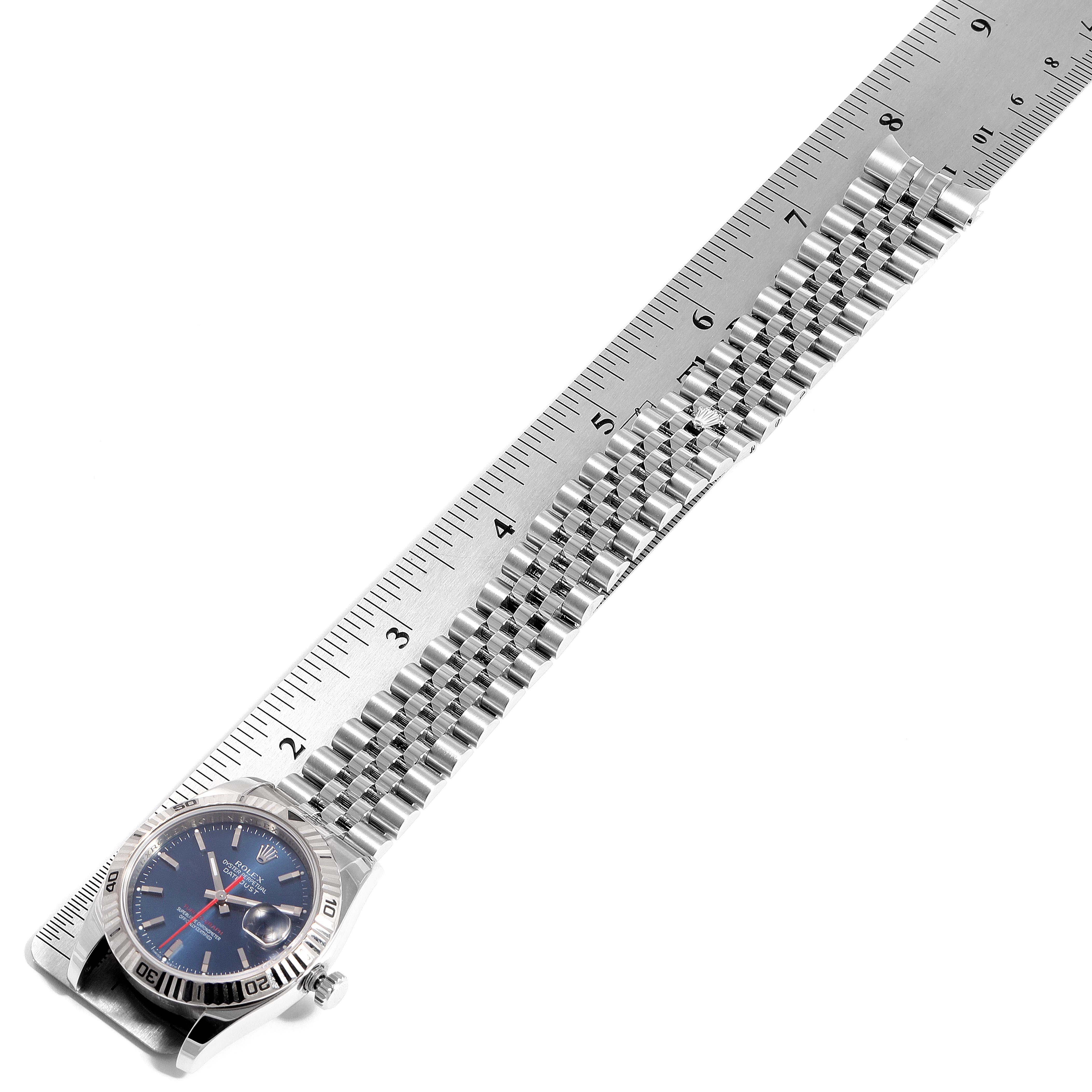 The image shows the Rolex Turn-o-Graph 116264 Men
s Stainless Steel Blue Dial 116264 Men
s Stainless Steel Blue Dial watch positioned with its bracelet extended alongside a ruler for measurement.
