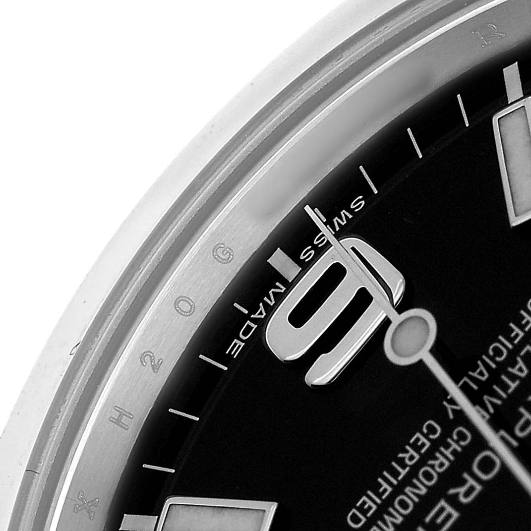 The image shows a close-up of the Rolex Explorer 214270 Men's Stainless Steel Black Dial watch's dial, highlighting the "9" marker and part of the minute and hour markers.