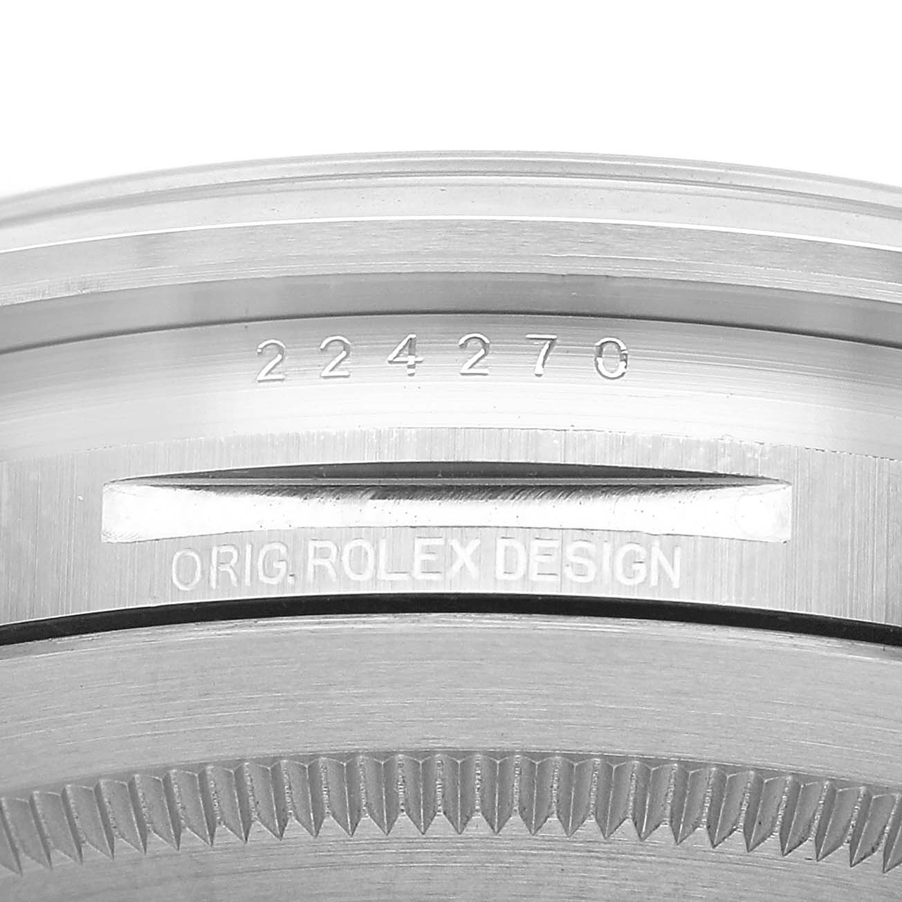 The image shows a close-up of a Rolex Explorer 224270 Men's Stainless Steel Black Dial watch, highlighting the engraved "ORIG. ROLEX DESIGN" and serial number on the case.
